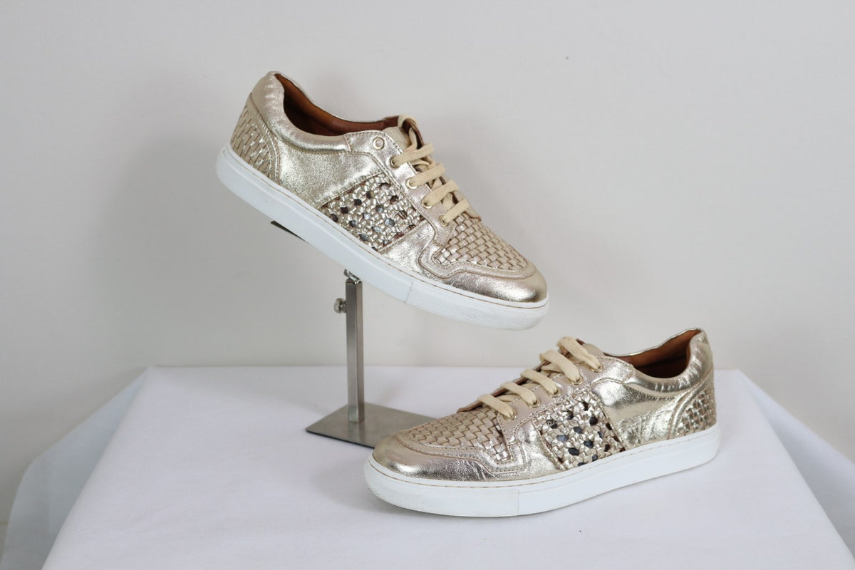 Paire de baskets basses Bocage dorées avec empiècements tressés sur support – Frippin'Dealz – photo retouchée par IA