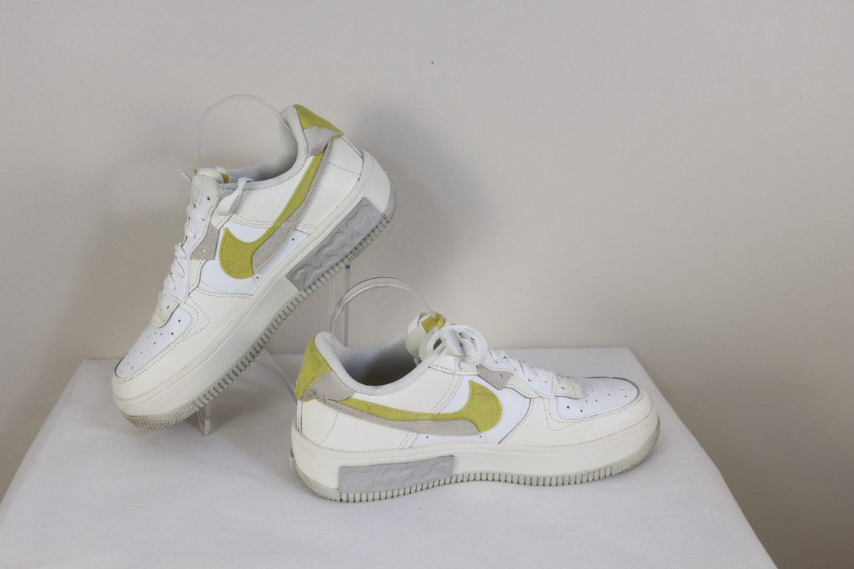 Paire de baskets Nike Fontanka blanches et jaune citron présentée sur support – Frippin'Dealz