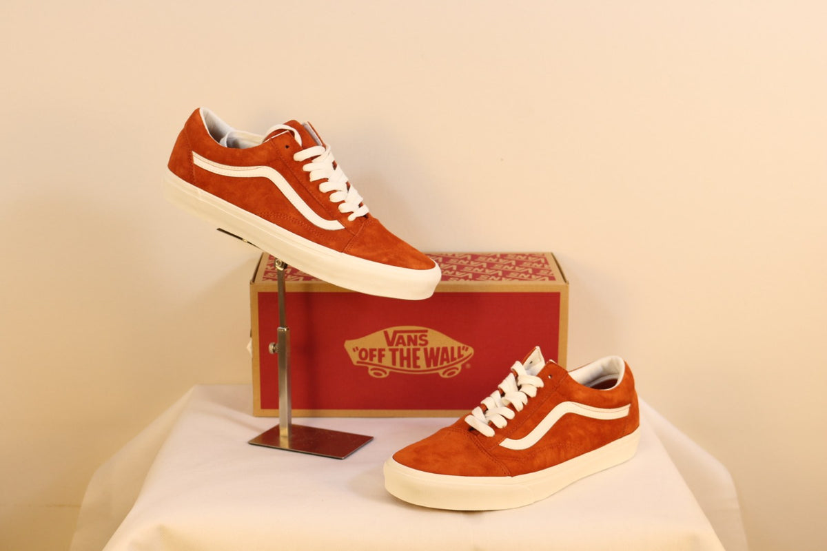 Paire de baskets Vans Old Skool orange brûlé, une basket présentée sur support métal devant la boîte – Frippin'Dealz