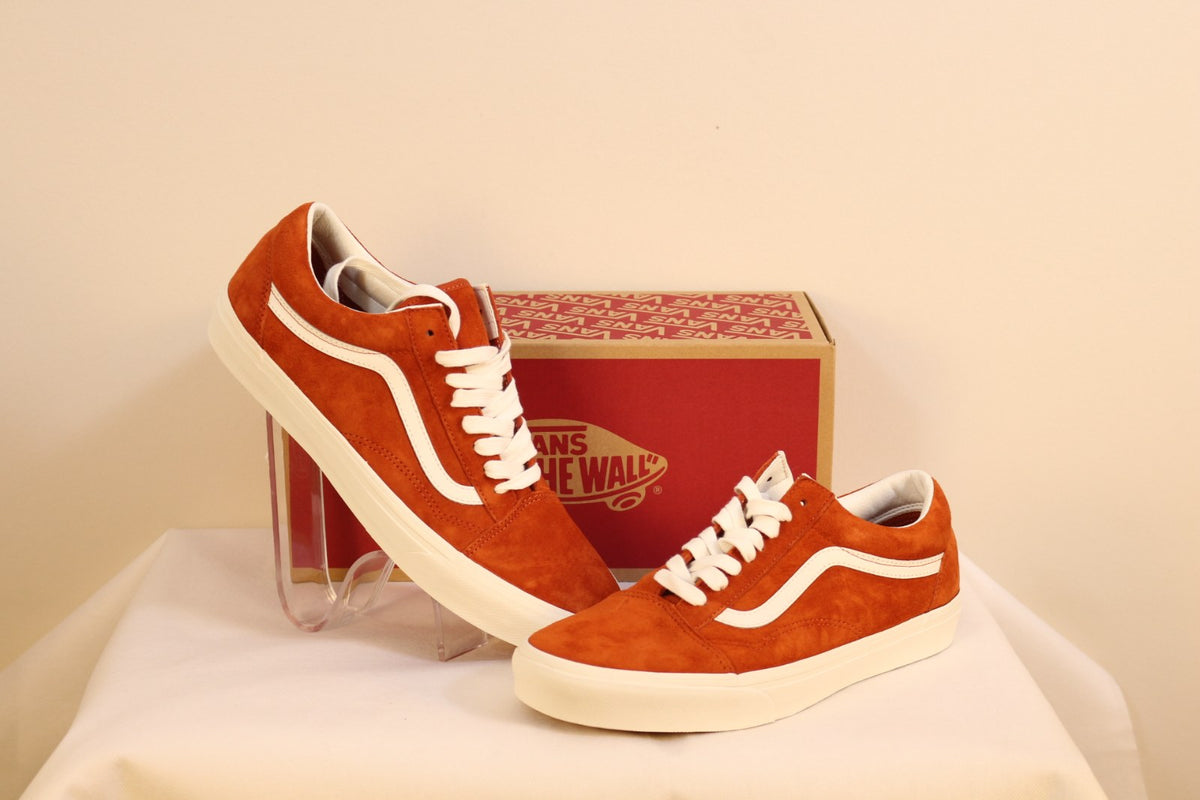 Paire de baskets Vans Old Skool en daim orange avec lacets blancs, présentée sur support transparent – Frippin'Dealz
