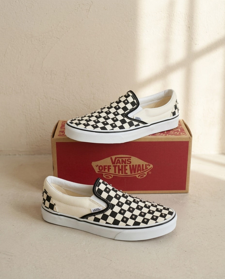 Baskets Vans Classic Slip-On damier noir et blanc avec strass posées sur la boîte Vans – Frippin'Dealz – photo retouchée par IA