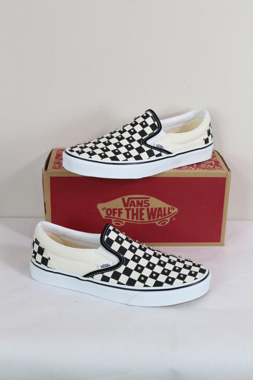 Baskets Vans Classic Slip-On damier noir et blanc avec strass posées sur la boîte Vans – Frippin'Dealz