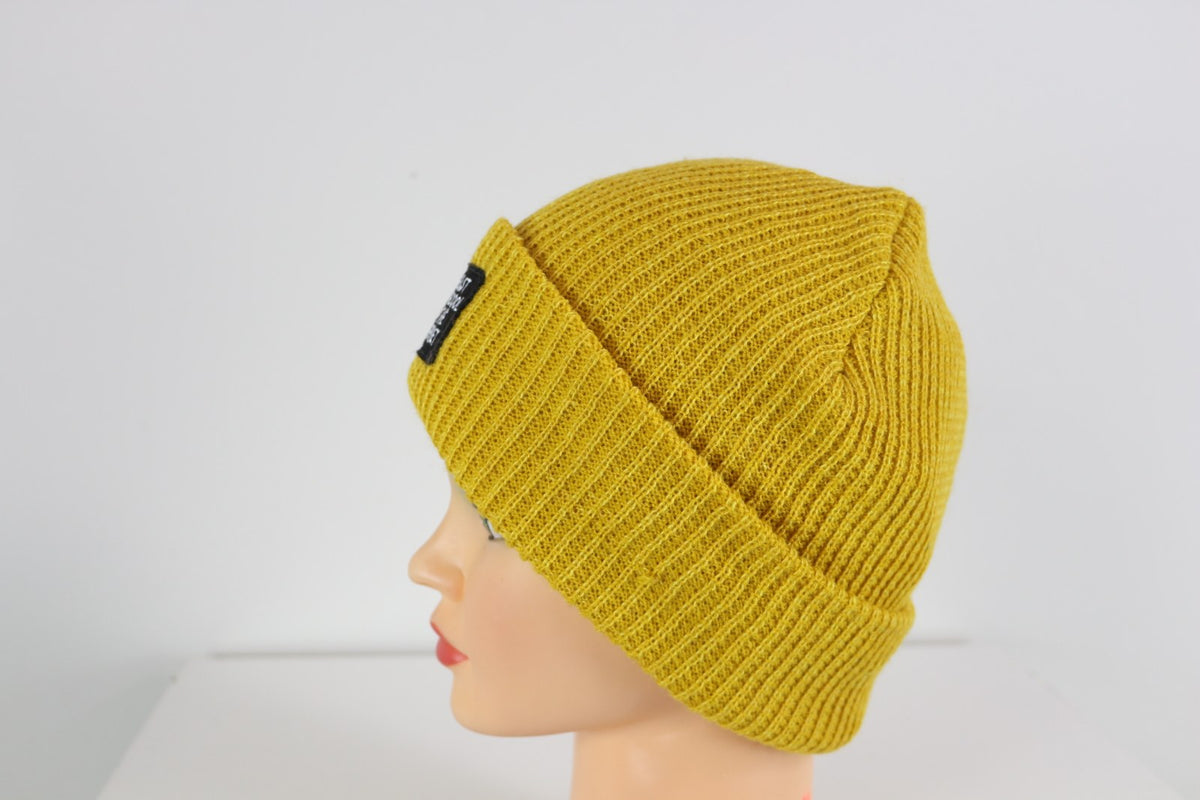Bonnet Eva&Co jaune moutarde à revers avec écusson noir, vue de profil gauche – Frippin'Dealz