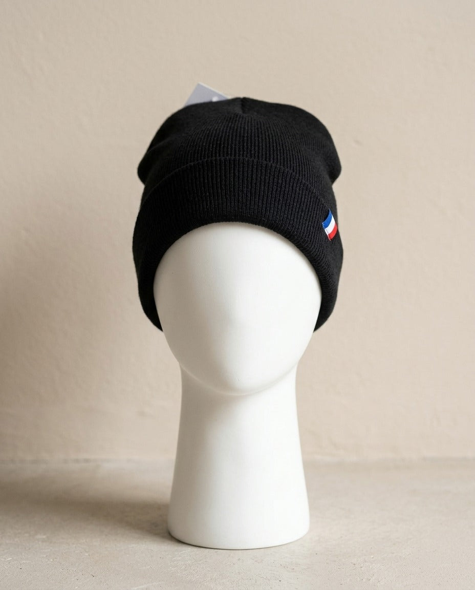 Bonnet French Touch noir à revers avec petit écusson tricolore, porté sur mannequin – Frippin'Dealz – photo retouchée par IA