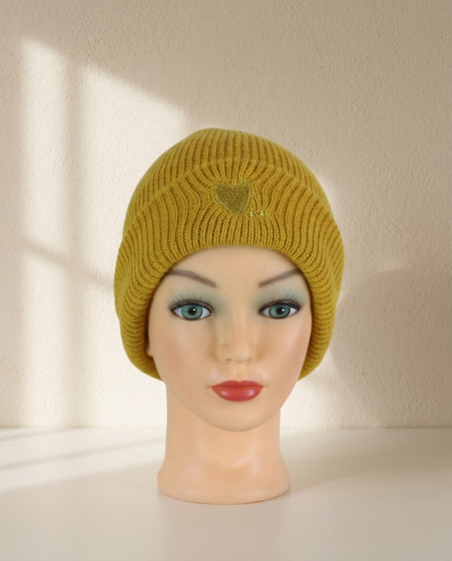 Bonnet Camaïeu côtelé moutarde à revers avec cœur brodé porté sur mannequin – Frippin'Dealz – photo retouchée par IA