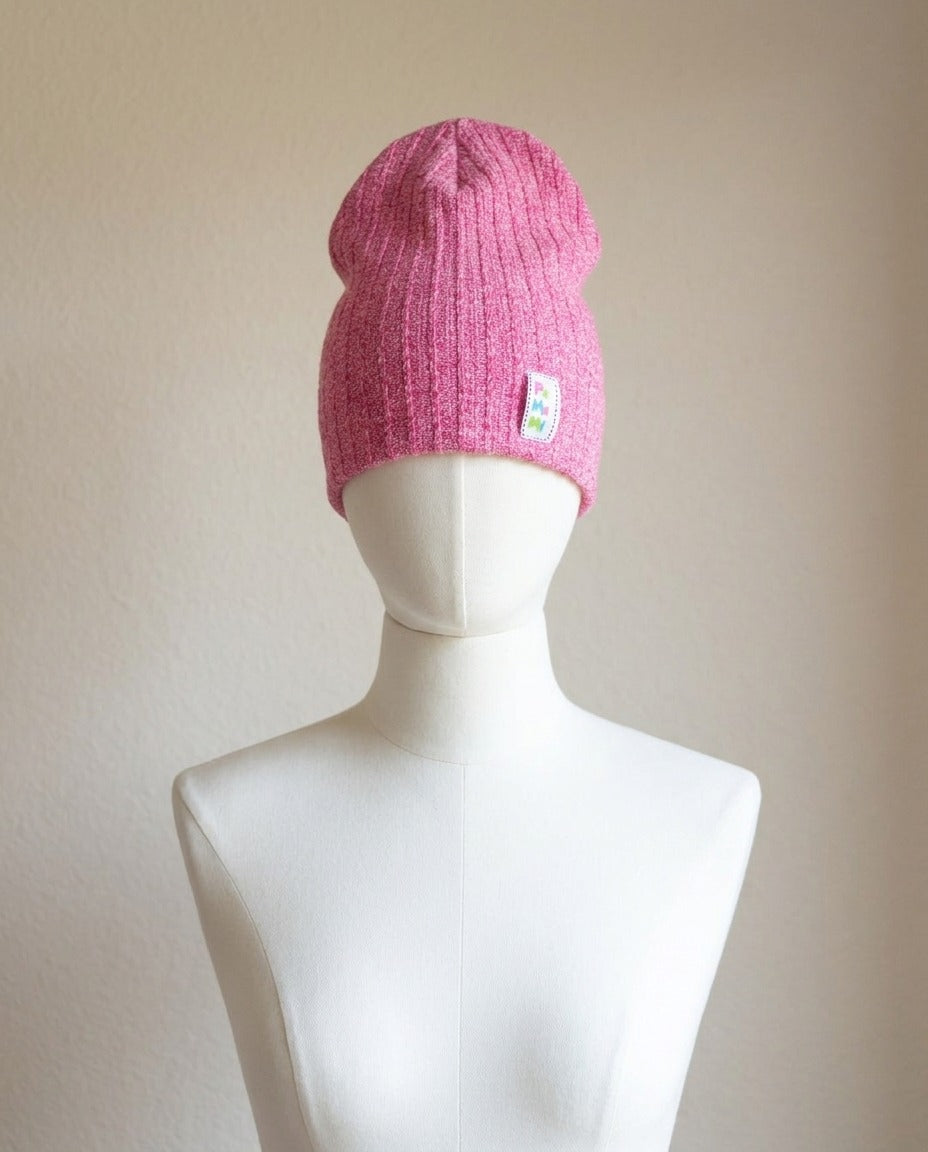 Bonnet PaMaMi rose fuchsia chiné en maille côtelée sur support en bois – Frippin'Dealz – photo retouchée par IA