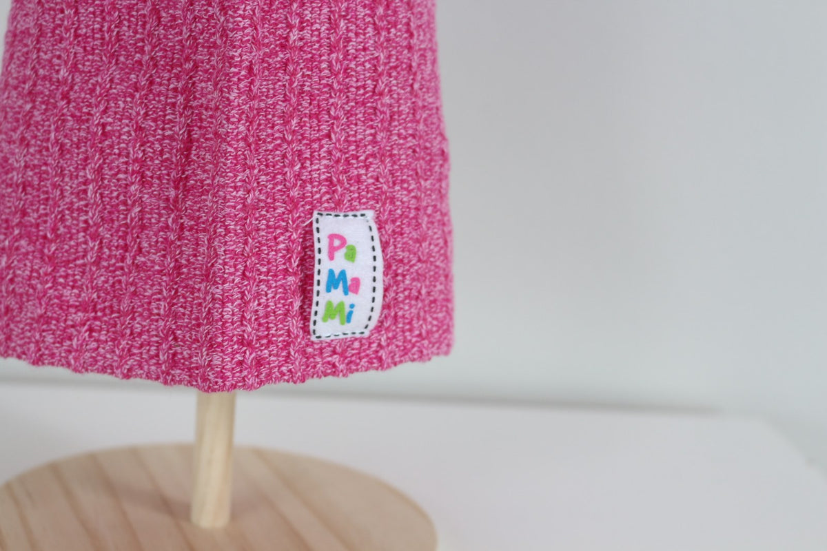 Gros plan sur l'écusson PaMaMi cousu sur le bonnet rose en maille côtelée – Frippin'Dealz