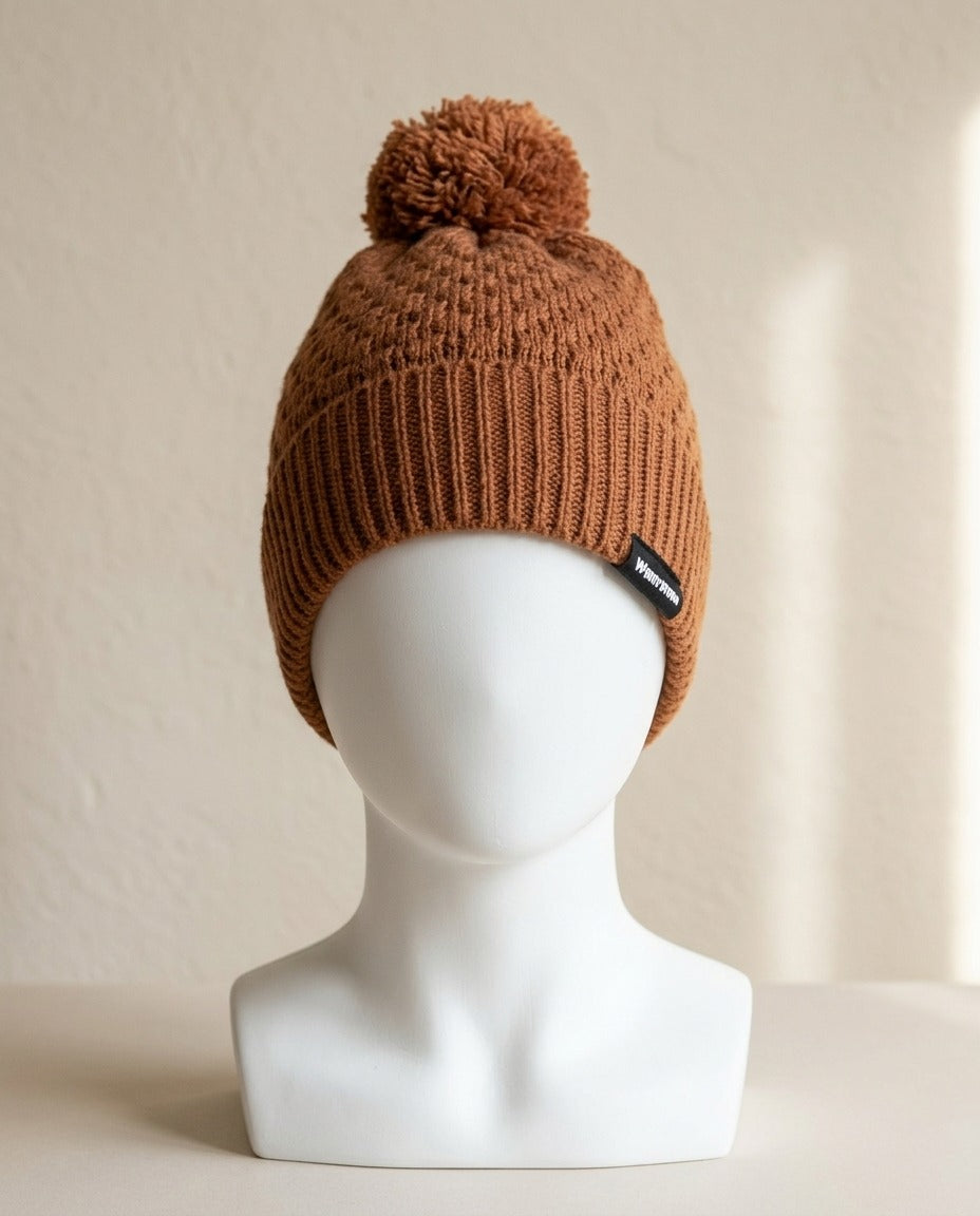 Bonnet Twentyfour cognac à pompon porté sur une tête de présentation, vue de face – Frippin'Dealz – photo retouchée par IA