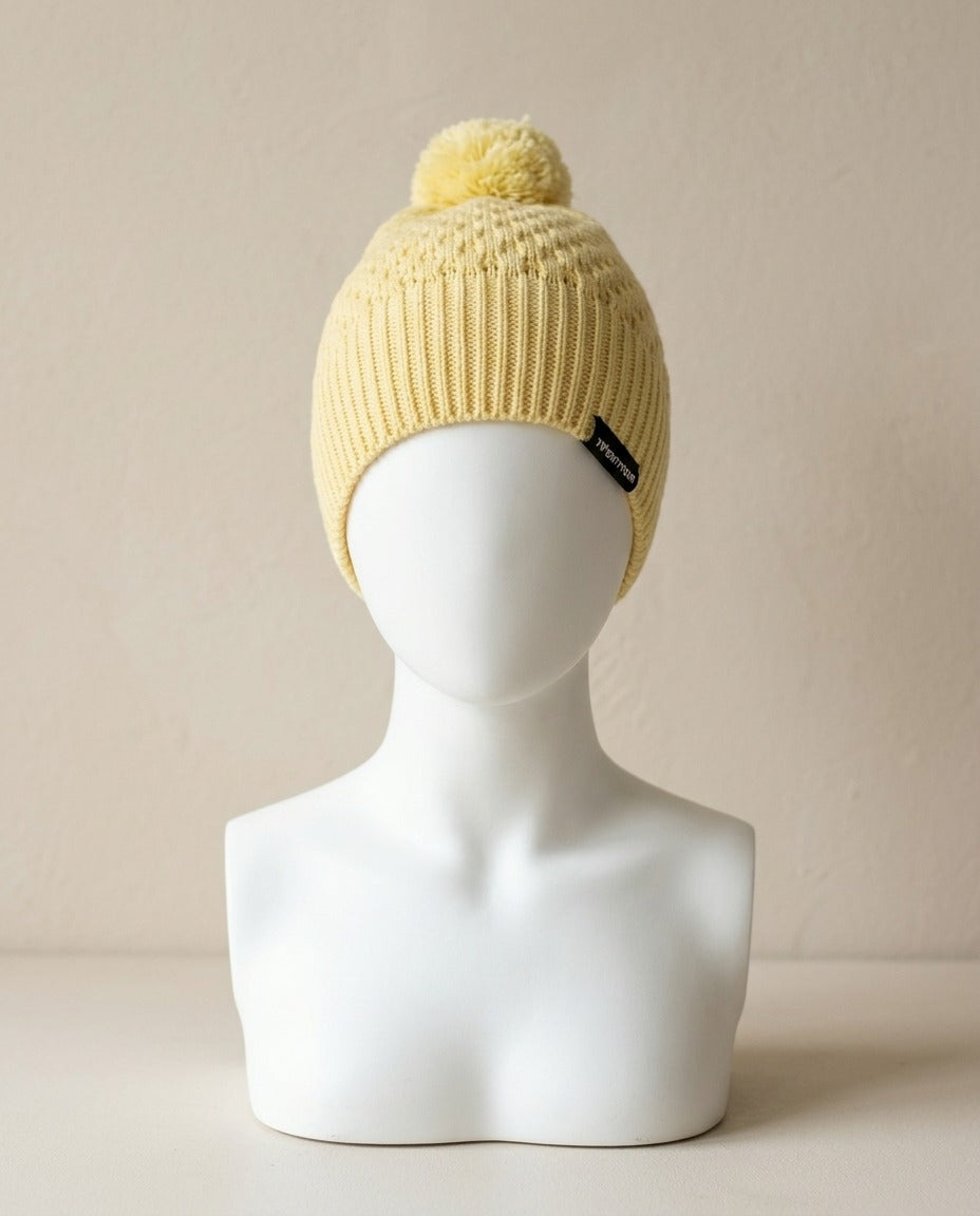 Bonnet Twentyfour jaune banane à pompon porté sur une tête de mannequin, vue de face – Frippin'Dealz – photo retouchée par IA