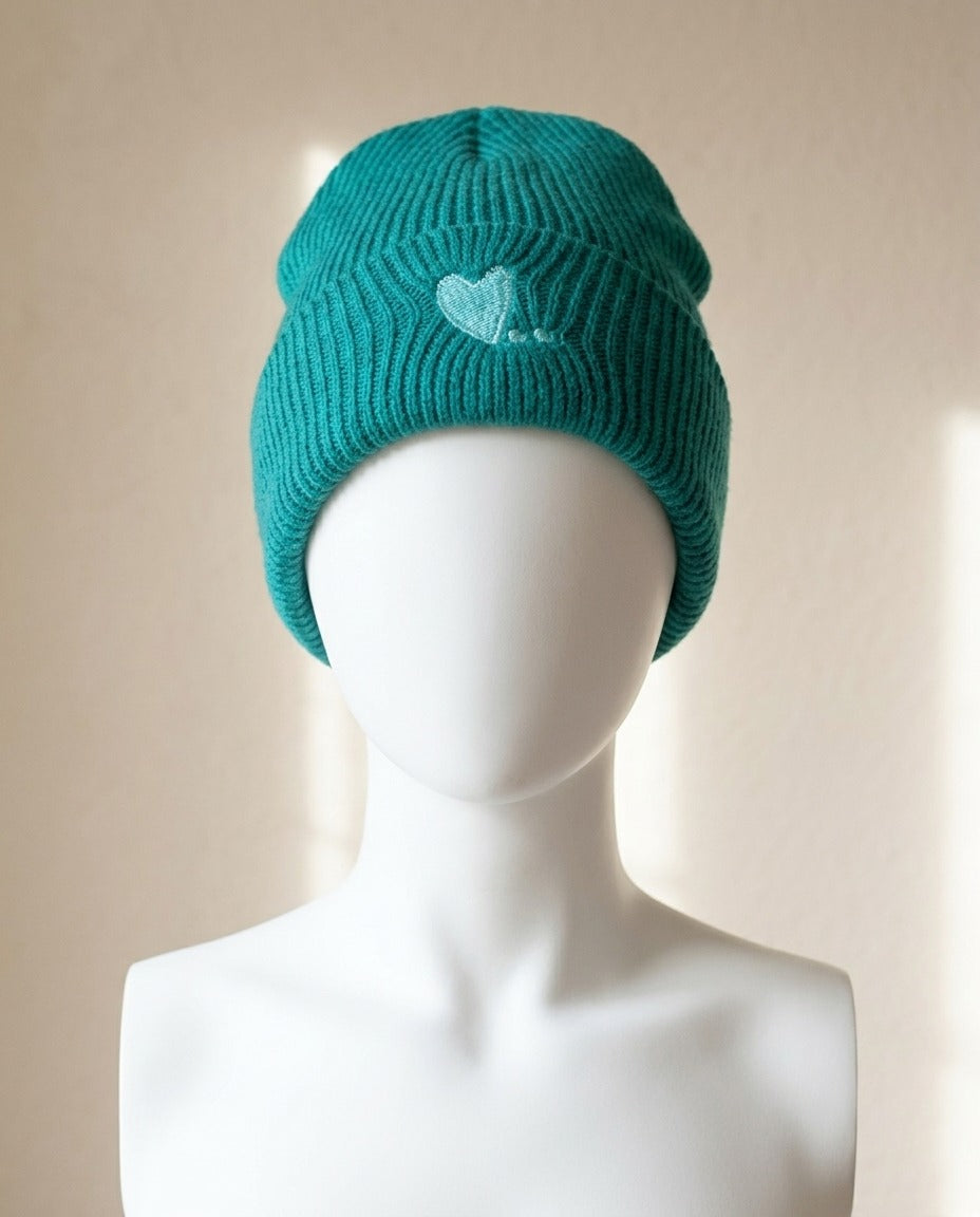 Bonnet Camaïeu vert émeraude côtelé avec cœur brodé porté sur mannequin – Frippin'Dealz – photo retouchée par IA