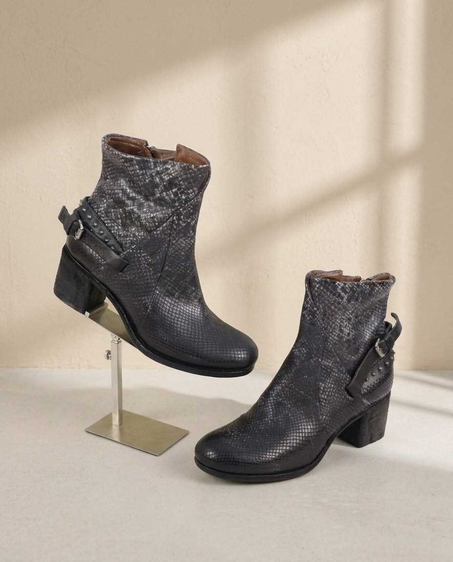 Bottines A.S.98 noires effet python avec bride cloutée et talon bloc, posées sur leur boîte – Frippin'Dealz – photo retouchée par IA