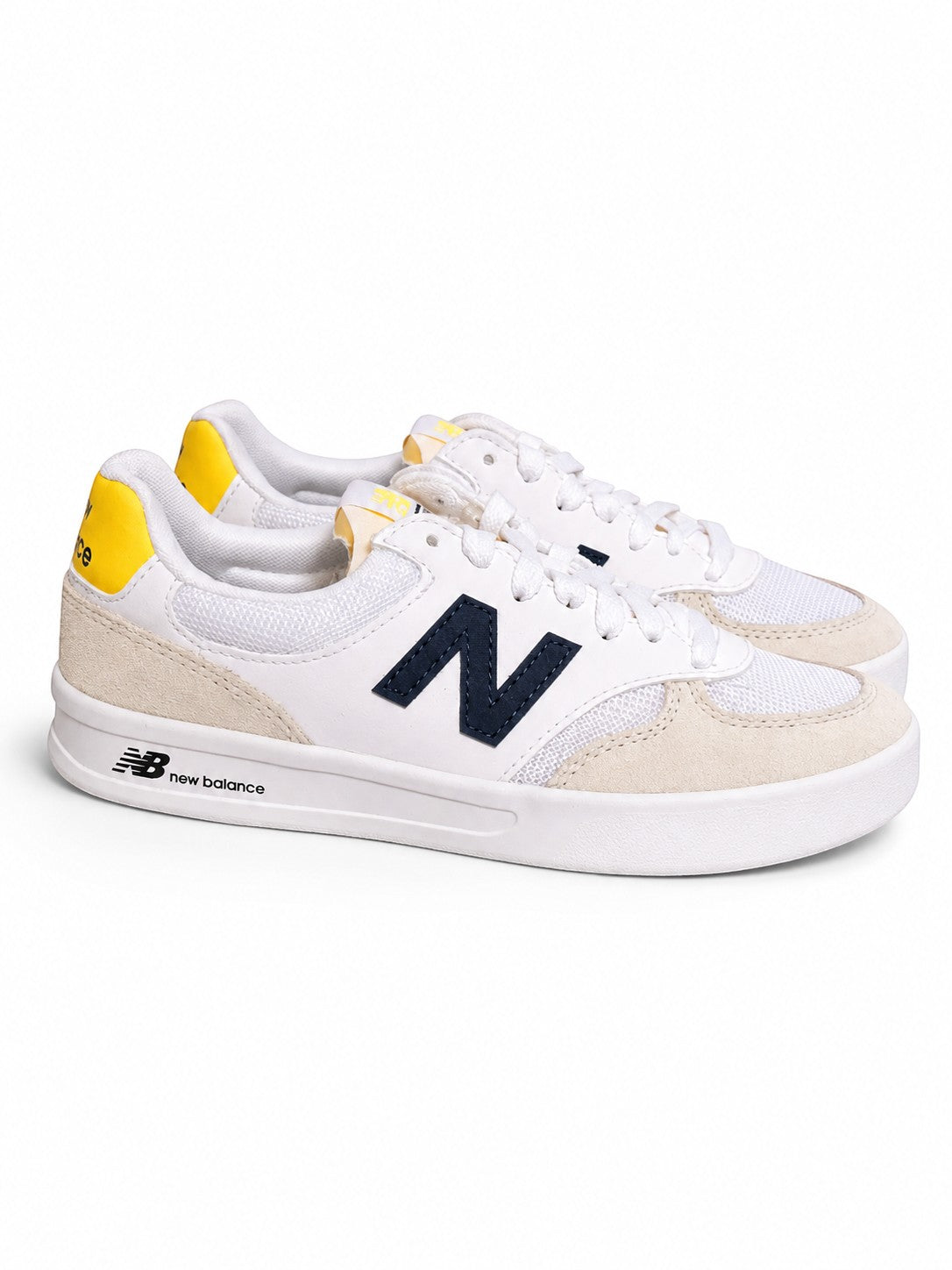 Baskets Frippindealz New Balance en cuir blanc avec logo N bleu marine et détails jaunes, style décontracté.