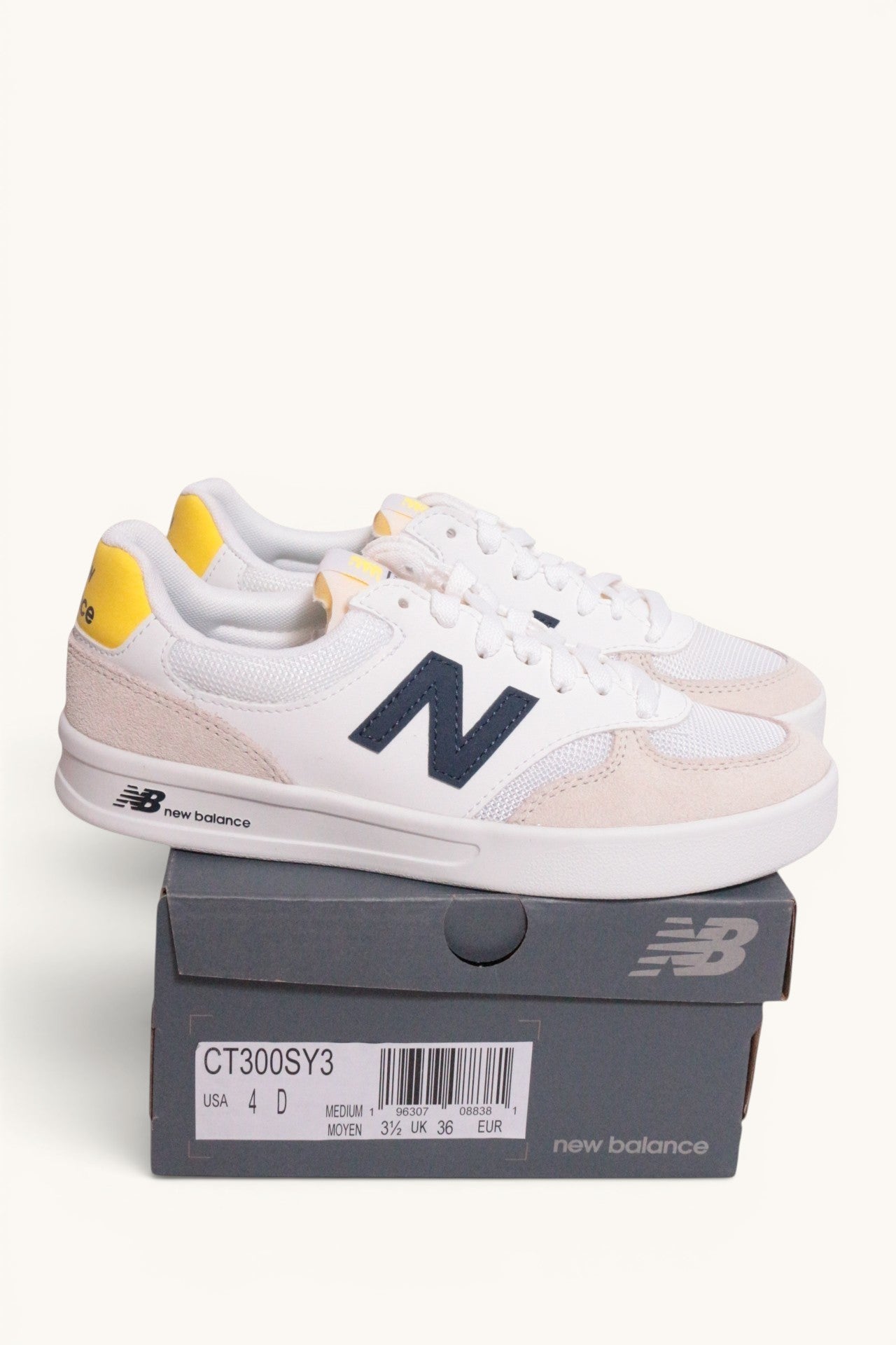 Baskets New Balance Frippindealz blanches en cuir et mesh avec logo bleu et détails jaunes sur la boîte d'origine
