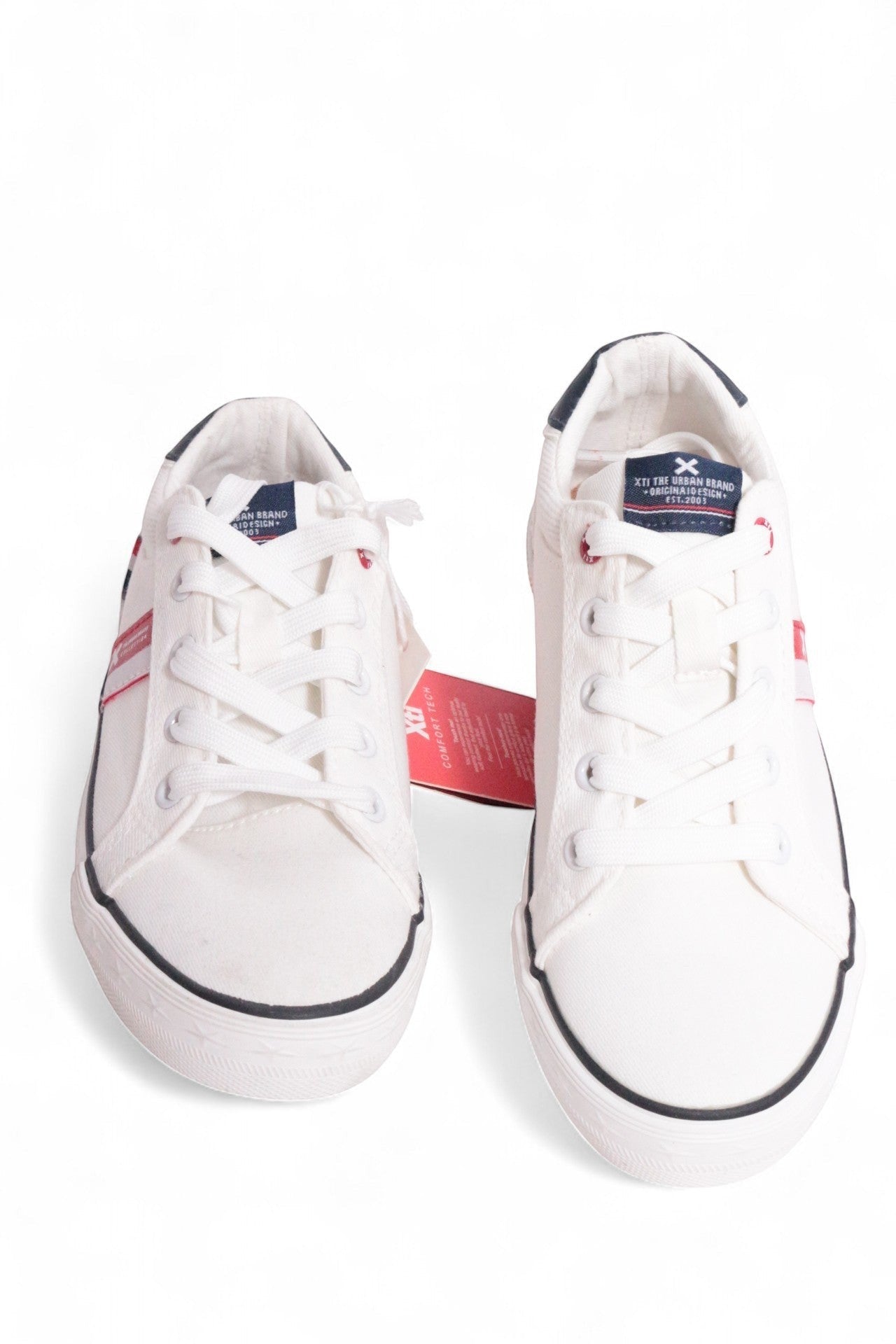 Frippindealz Baskets XTI blanches en textile pour enfants, lacets blancs, détails rouges et semelle noire.