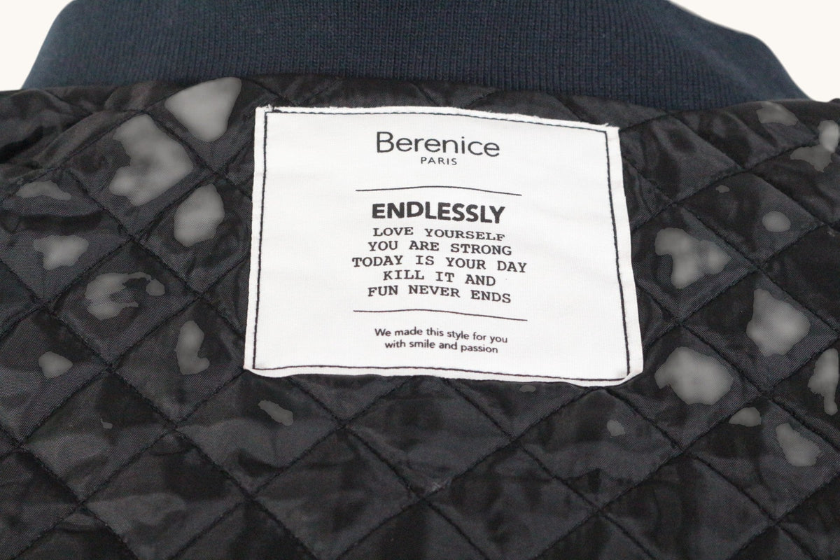 Étiquette intérieure de blouson Frippindealz Berenice avec doublure matelassée noire et message inspirant