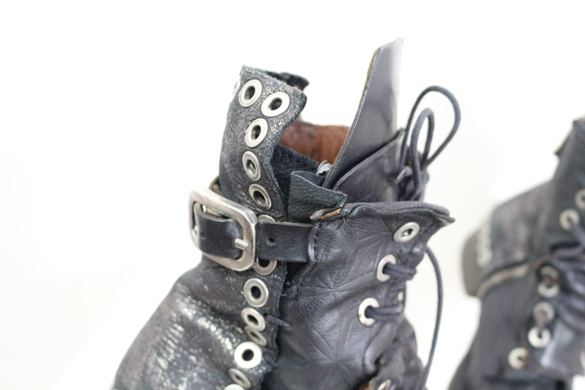 Bottes femme Frippindealz A.S.98 en cuir noir avec œillets métalliques et boucle réglable, style urbain