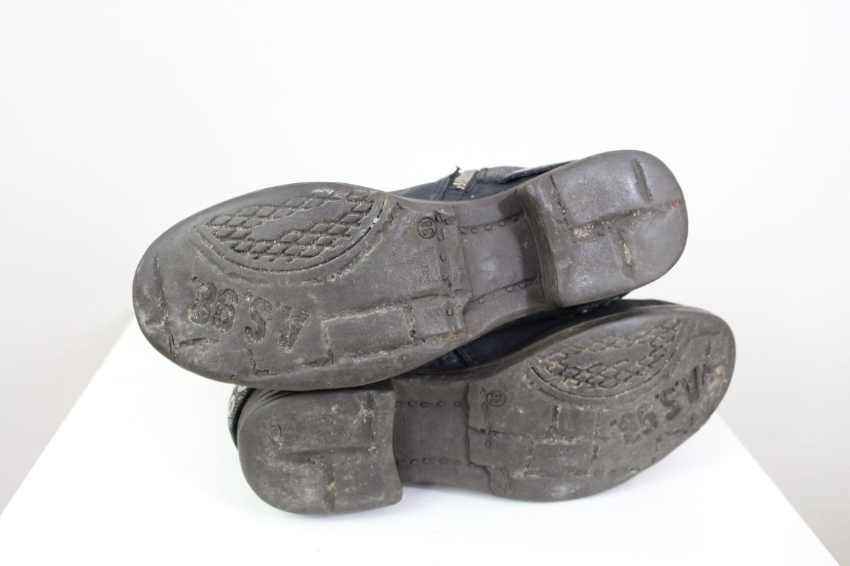 Semelles en caoutchouc noir des bottes en cuir Frippindealz A.S.98 avec logo de la marque visible