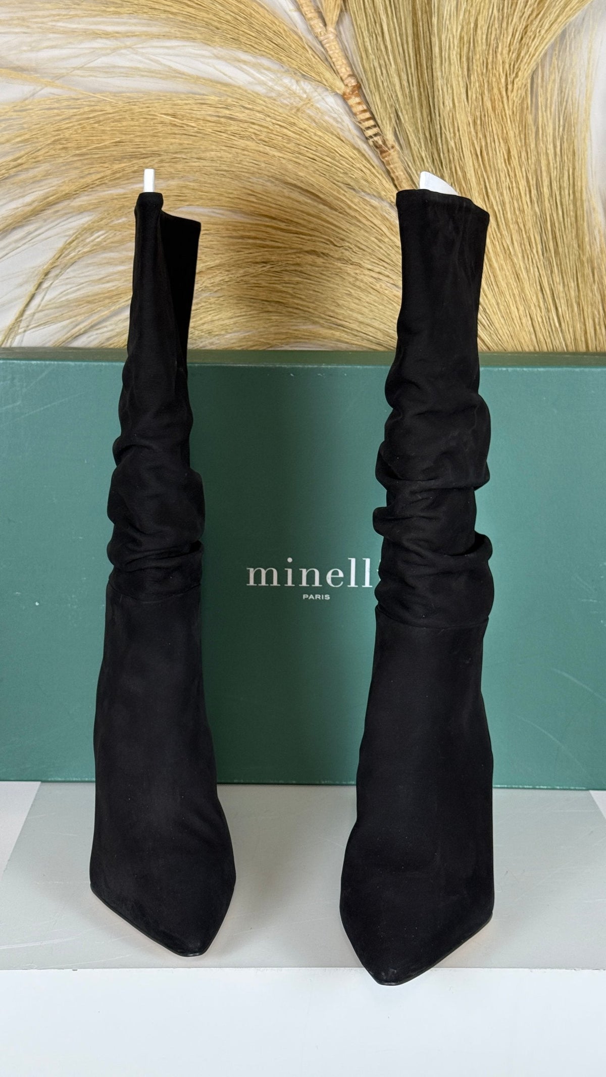 Bottes Frippindealz Minelli en nubuck noir avec tige froncée et talon compensé, présentées devant leur boîte