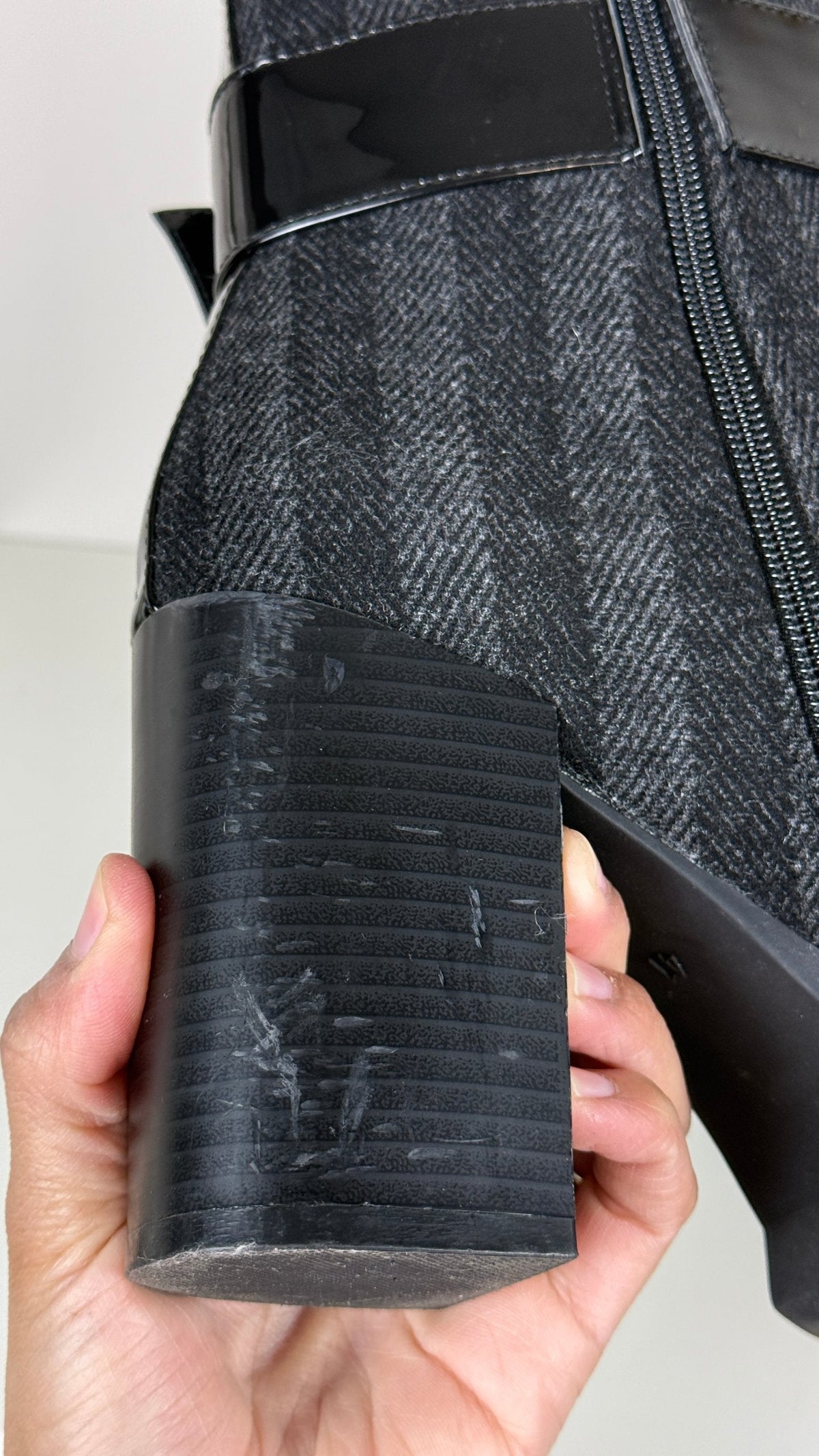Gros plan sur le talon épais noir de bottines Frippindealz avec texture en chevron et légères marques d'usure