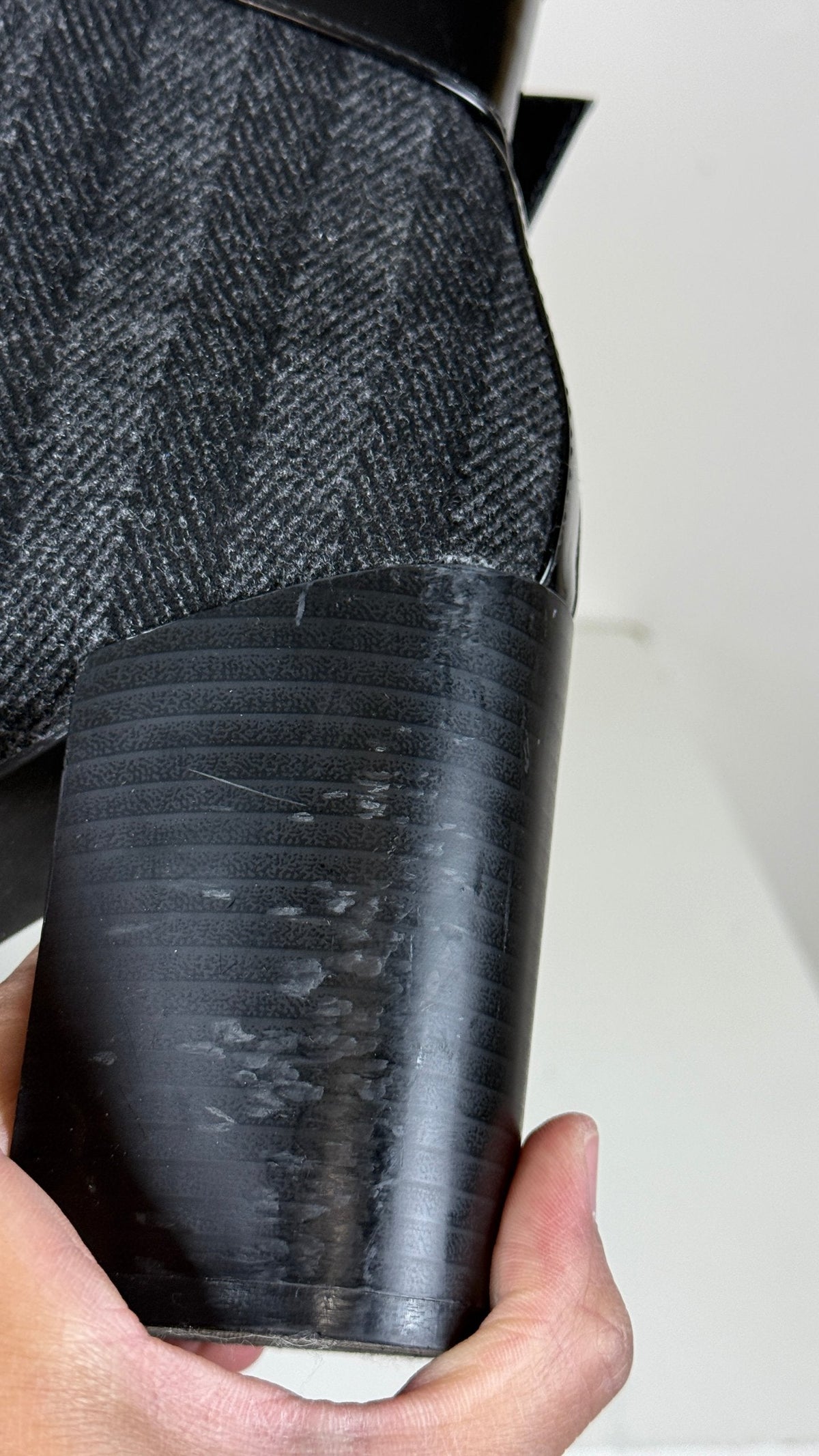 Gros plan sur le talon épais noir d'une bottine Frippindealz avec marques d'usure sur le revêtement