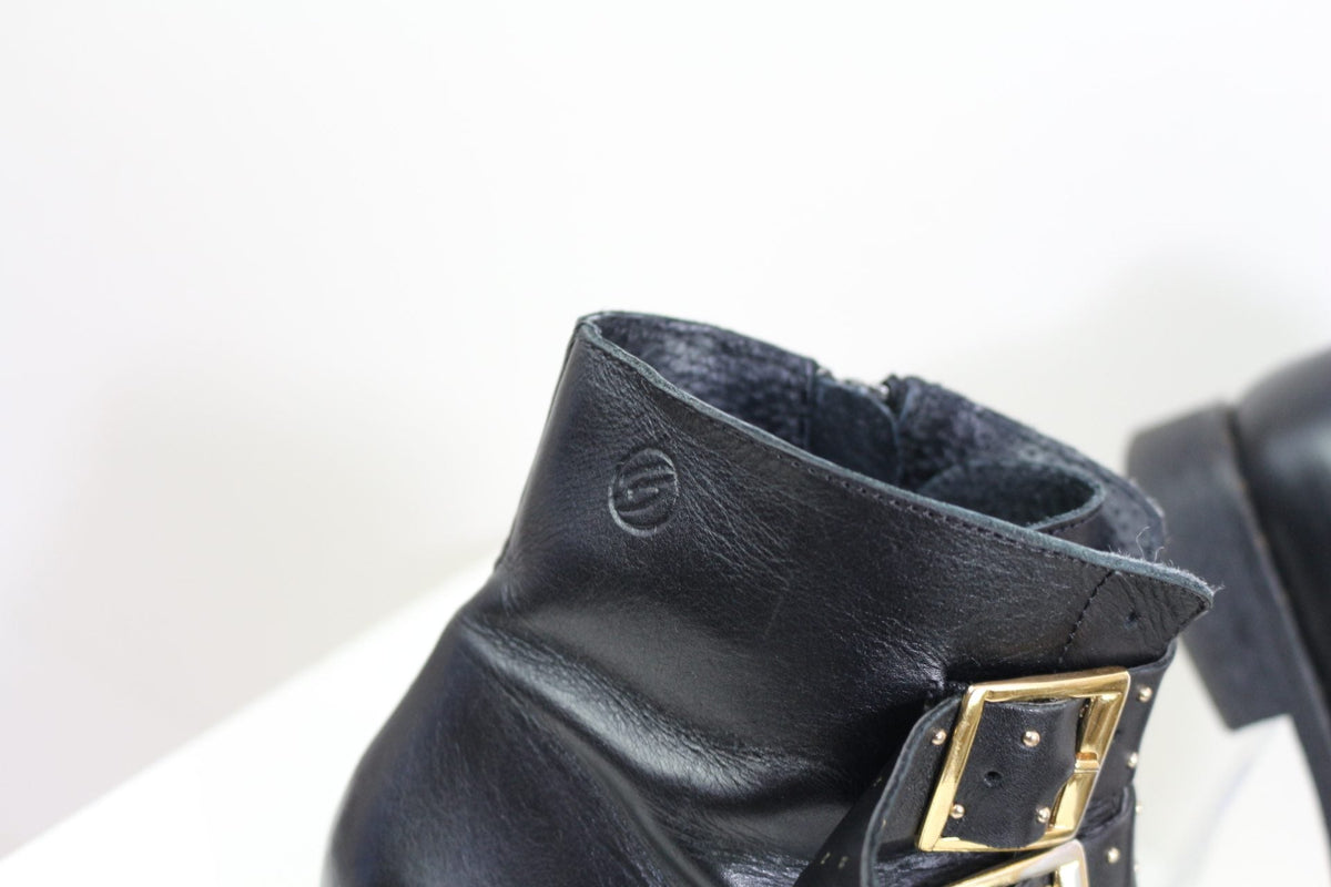 Bottines Frippindealz Betty London en cuir noir avec brides cloutées et boucles dorées, vue rapprochée du logo