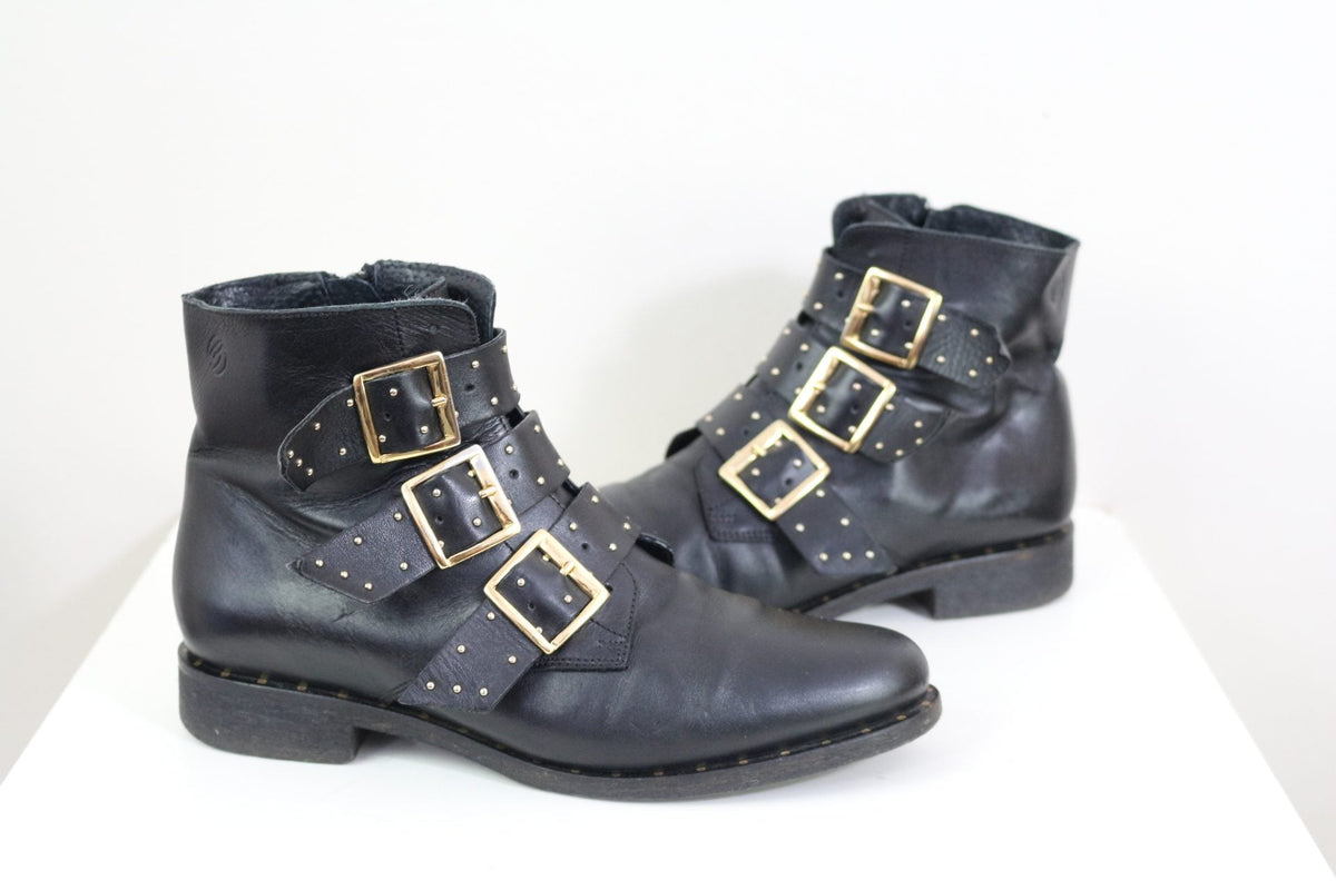 Bottines Frippindealz Betty London en cuir noir avec trois brides cloutées et boucles dorées style rock chic