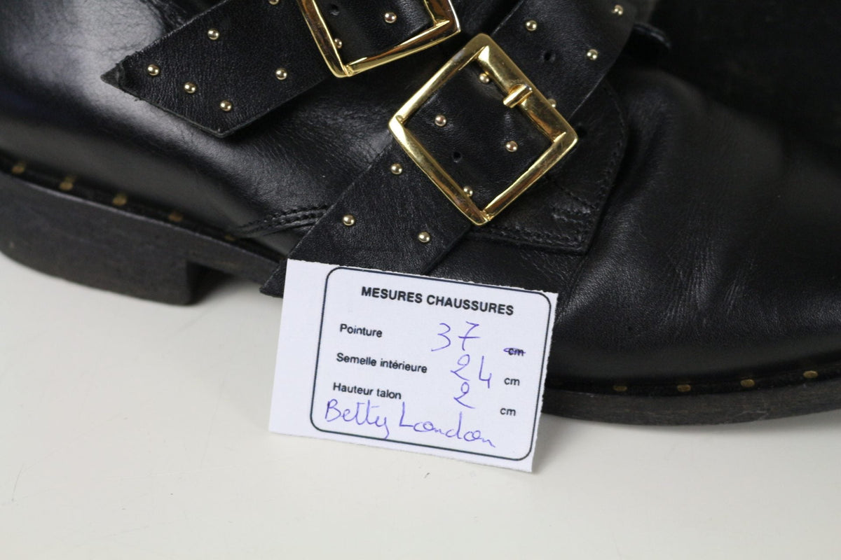 Bottines Frippindealz Betty London en cuir noir avec brides cloutées et boucles dorées, style rock chic