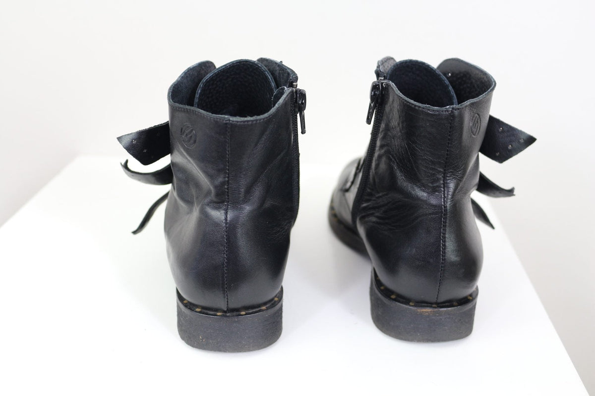 Vue arrière des bottines Frippindealz Betty London en cuir noir avec fermeture éclair latérale et détails cloutés