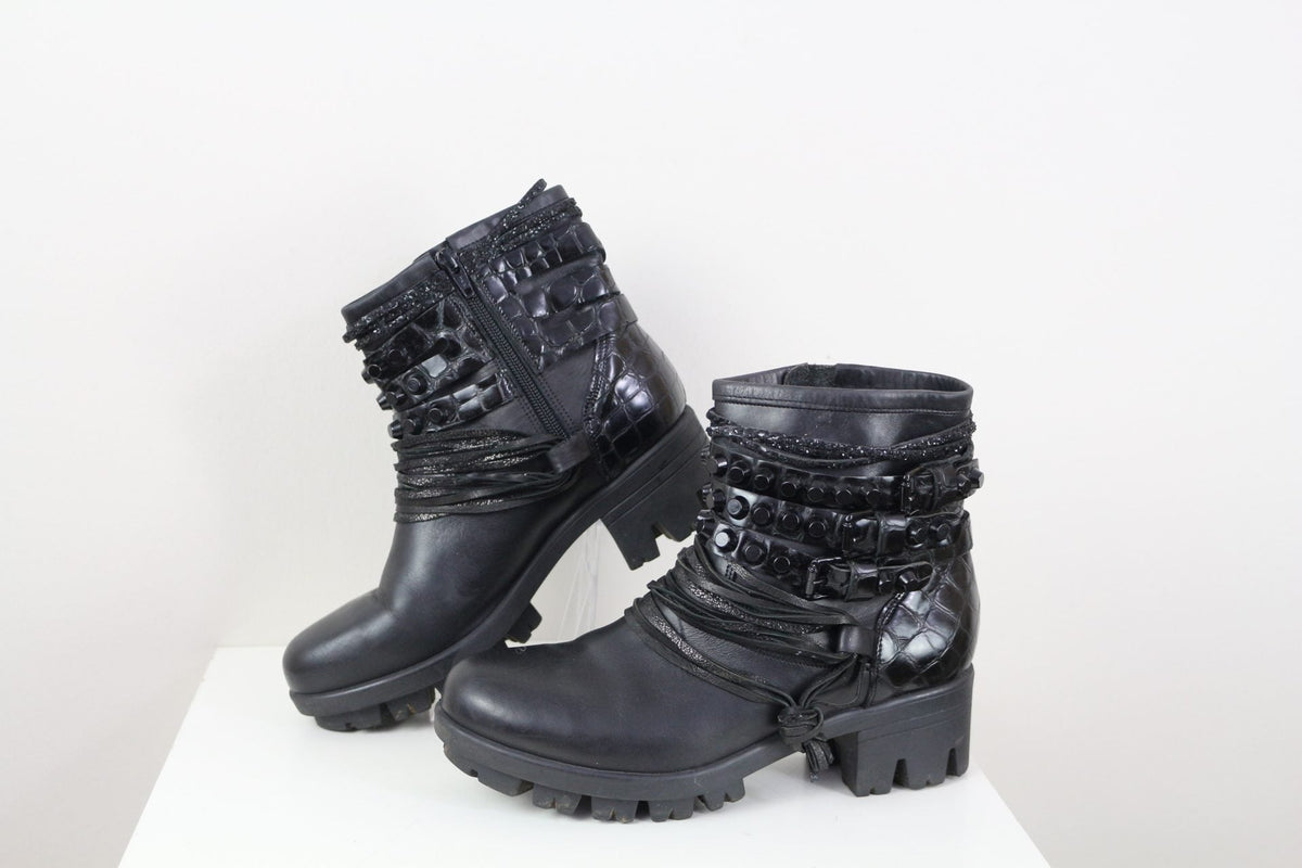 Bottines Frippindealz Mimmu noires en cuir avec clous, lanières et détails façon croco, style rock, talon 5 cm.
