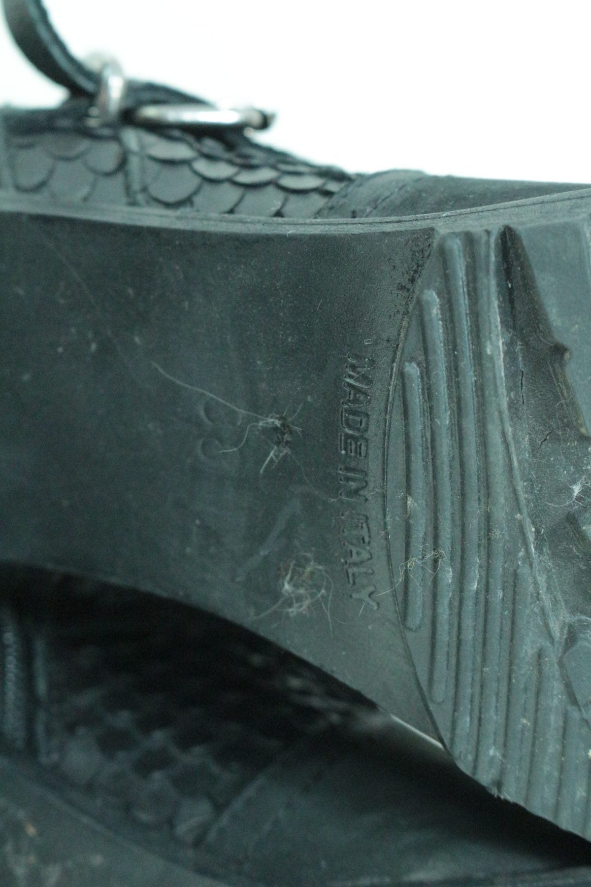 Gros plan sur la semelle noire d'une bottine Frippindealz avec inscription Made in Italy et texture effet reptile