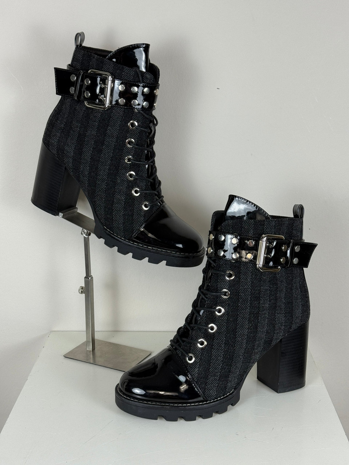 Bottines Frippindealz noires à talons hauts, cuir verni et laine, avec lacets, zip et boucle cloutée décorative.