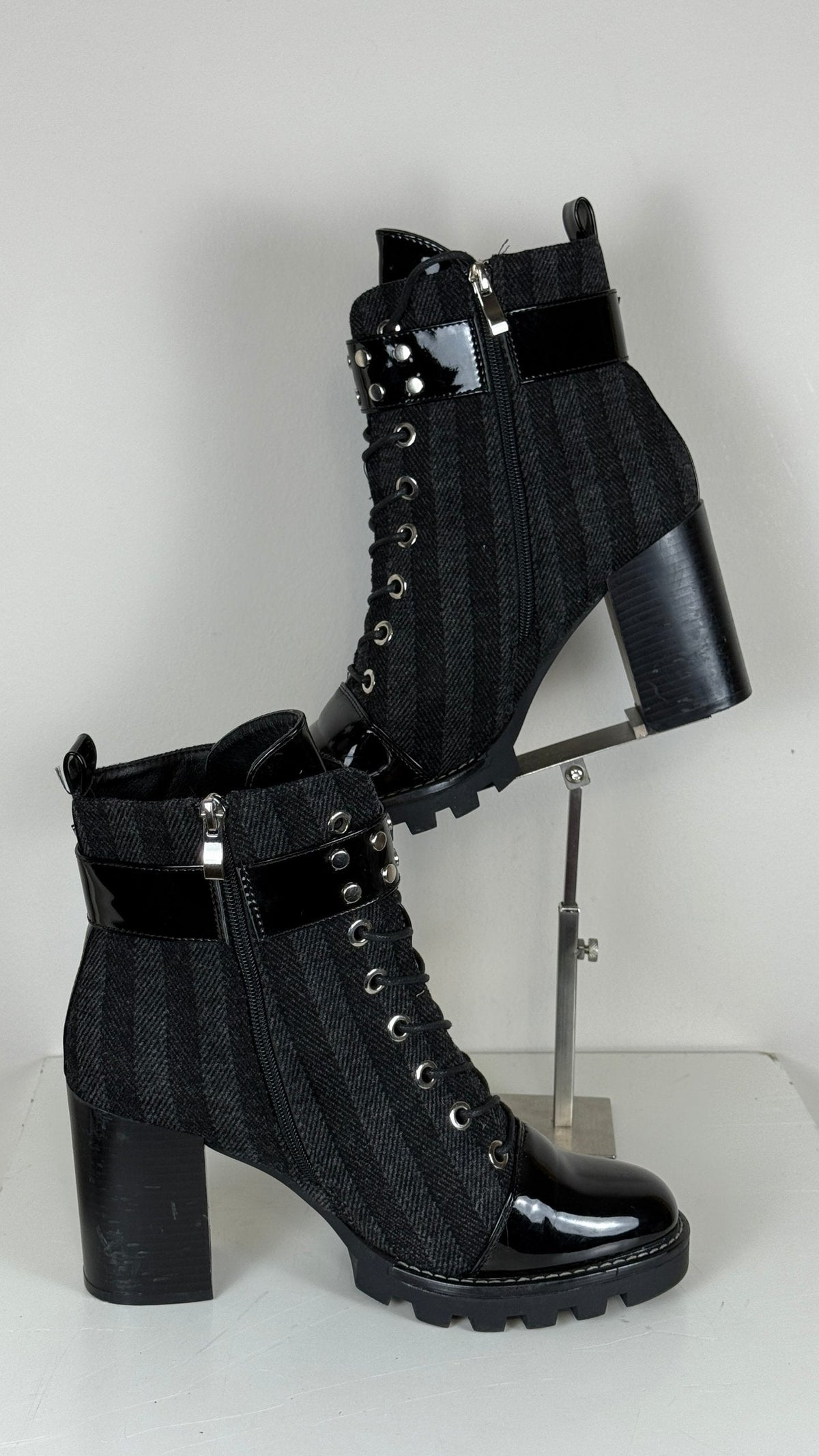 Bottines Frippindealz noires à talons hauts, cuir synthétique verni, lacets, zip latéral et détails cloutés.
