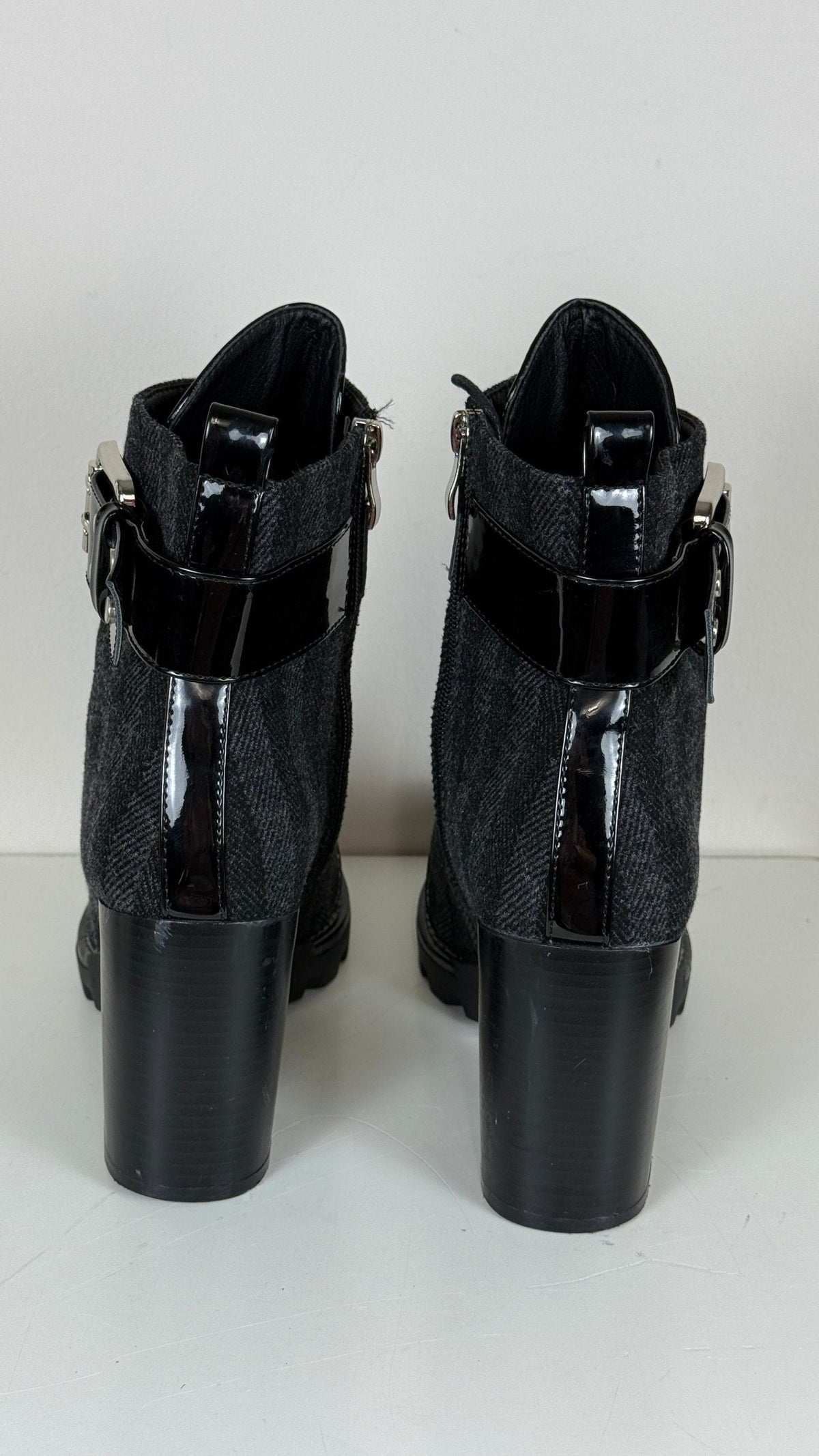 Bottines Frippindealz noires à talons hauts, mélange de cuir verni et laine, avec boucle décorative et fermeture zip.
