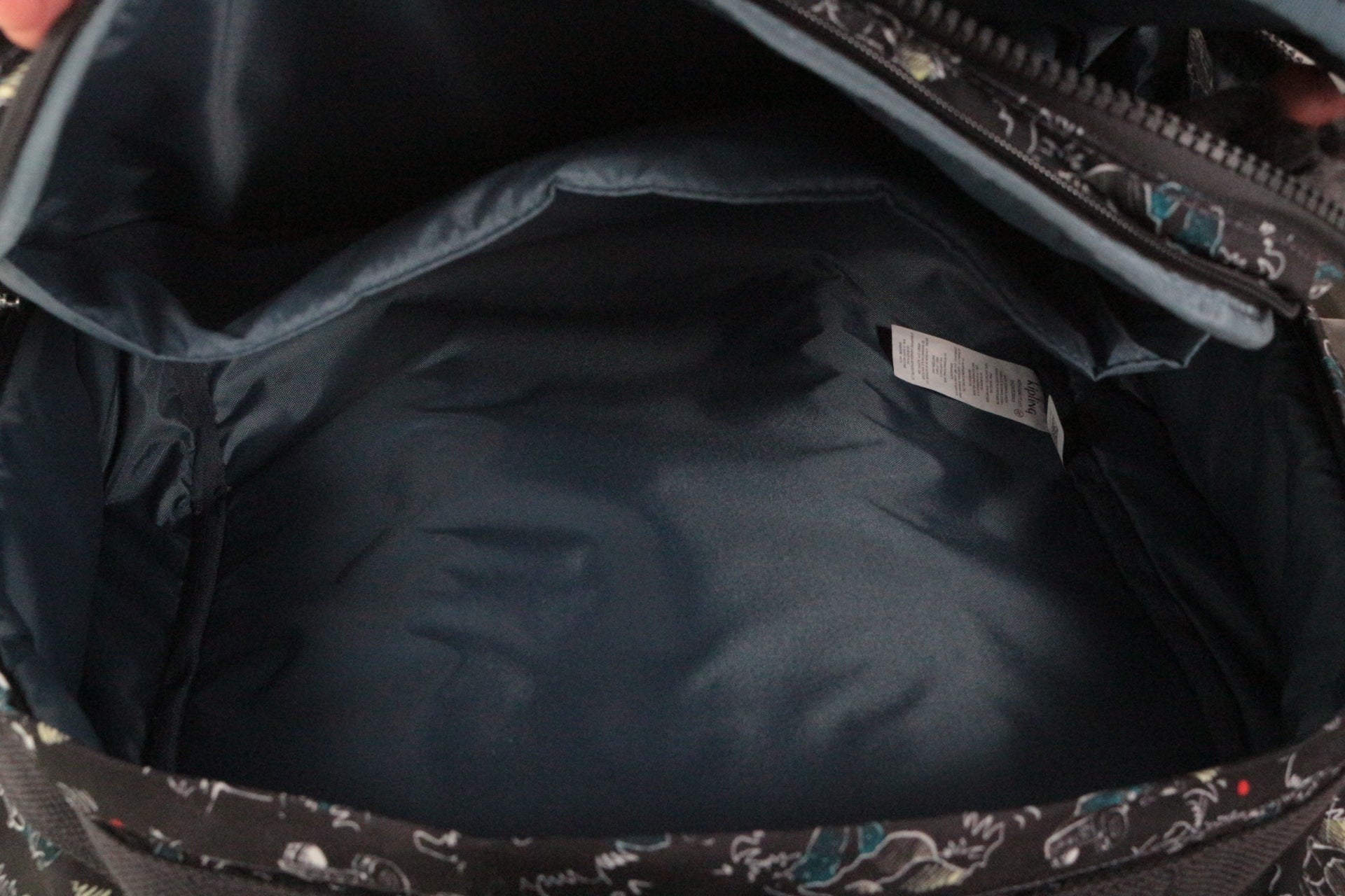 Intérieur spacieux du cartable à roulettes Frippindealz Kipling New Storia avec doublure bleu foncé et étiquette