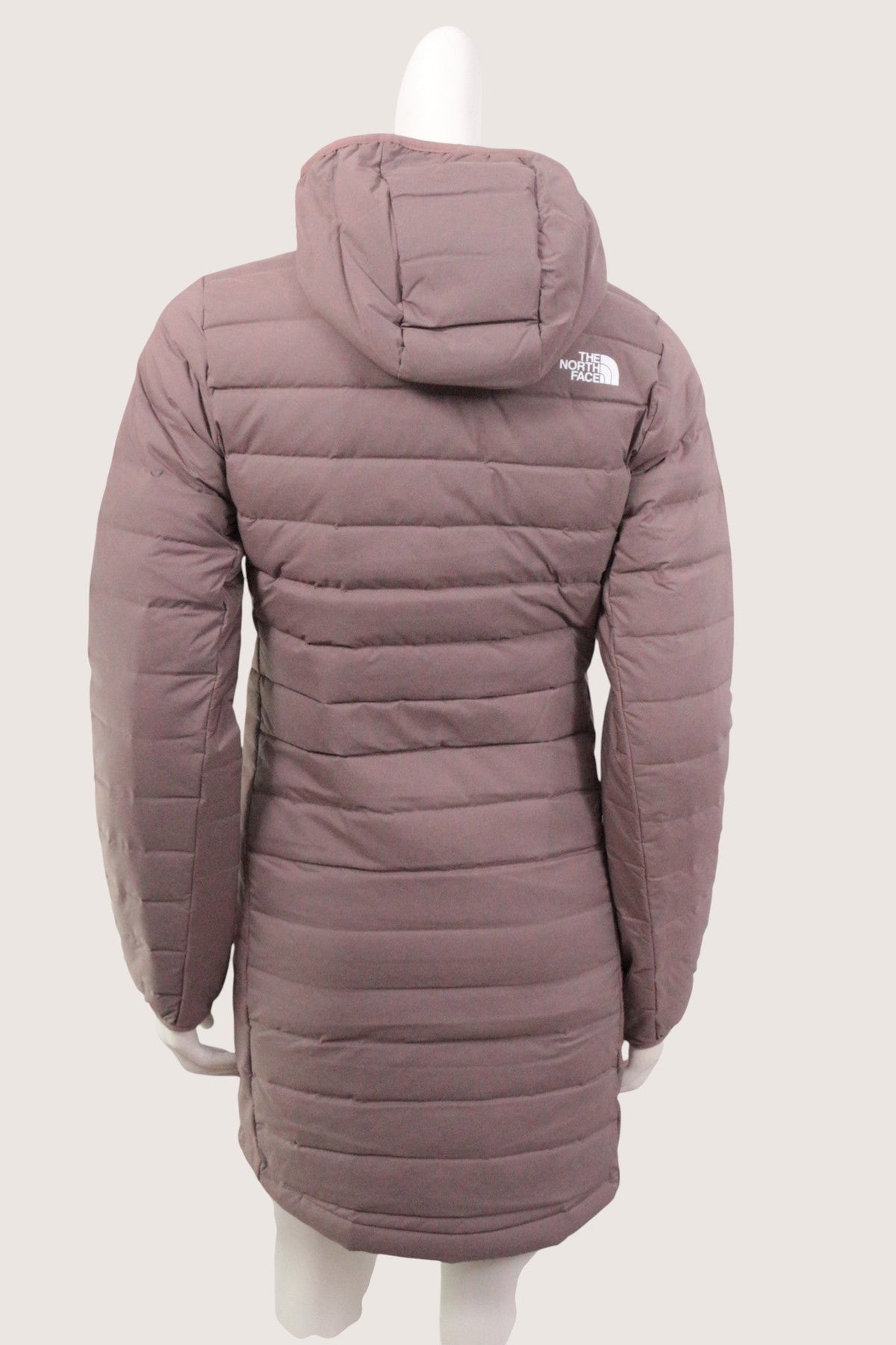 Doudoune beige Frippindealz The North Face avec capuche, vue arrière sur mannequin, design matelassé moderne.