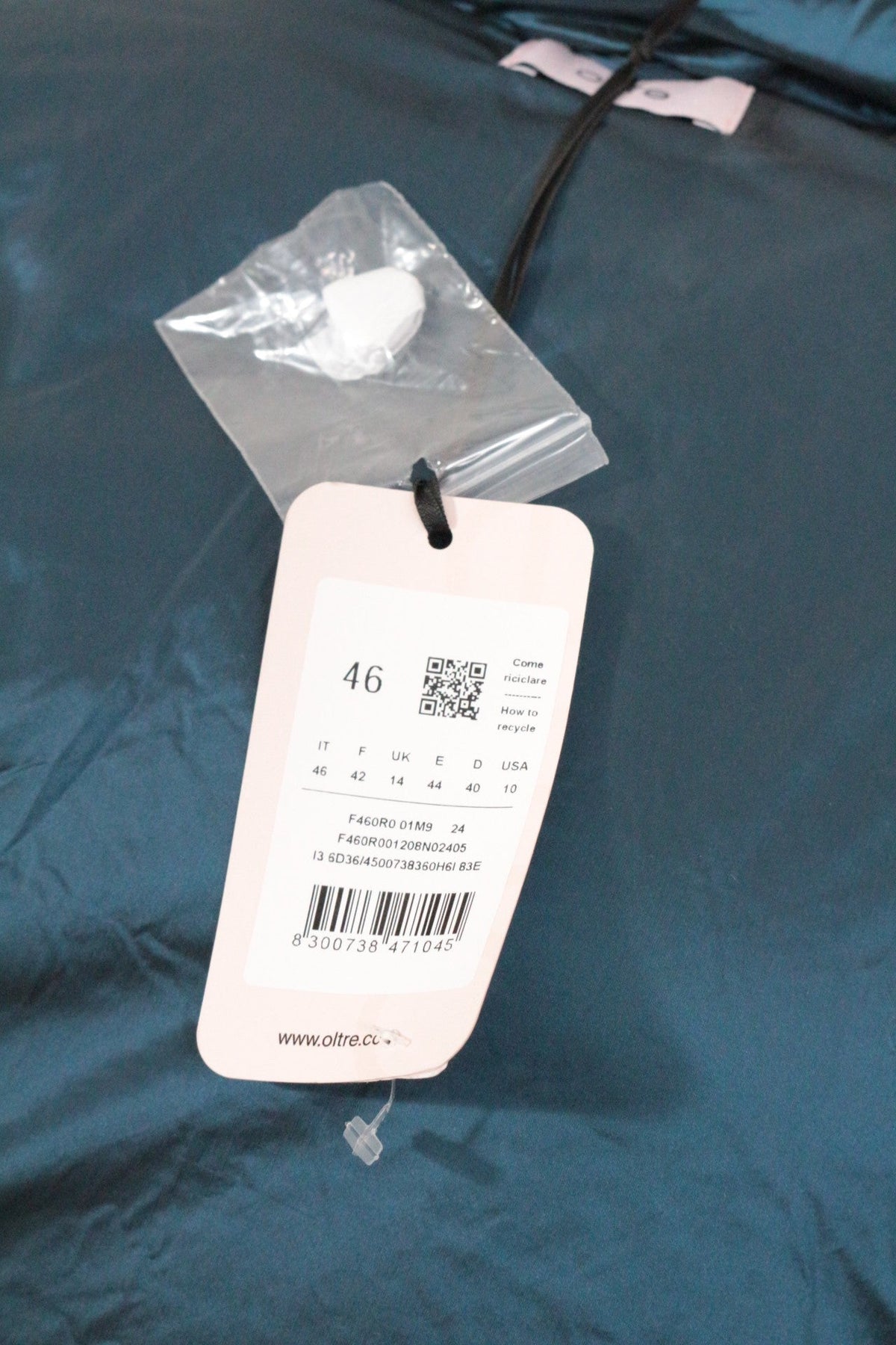 Etiquette de prix et informations de taille sur une doudoune bleu marine Frippindealz neuve