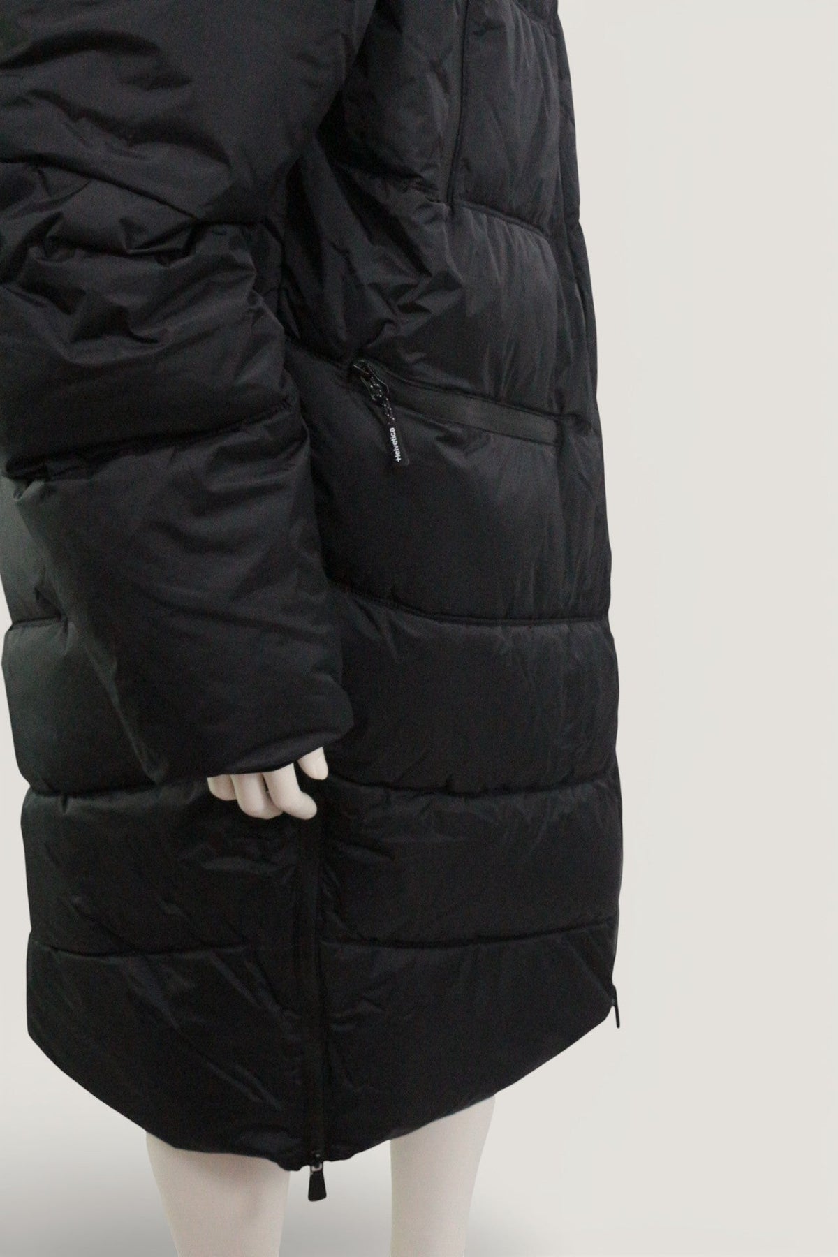 Doudoune longue noire Helvetica de Frippindealz en polyester avec fermeture zippée, vue de profil sur mannequin