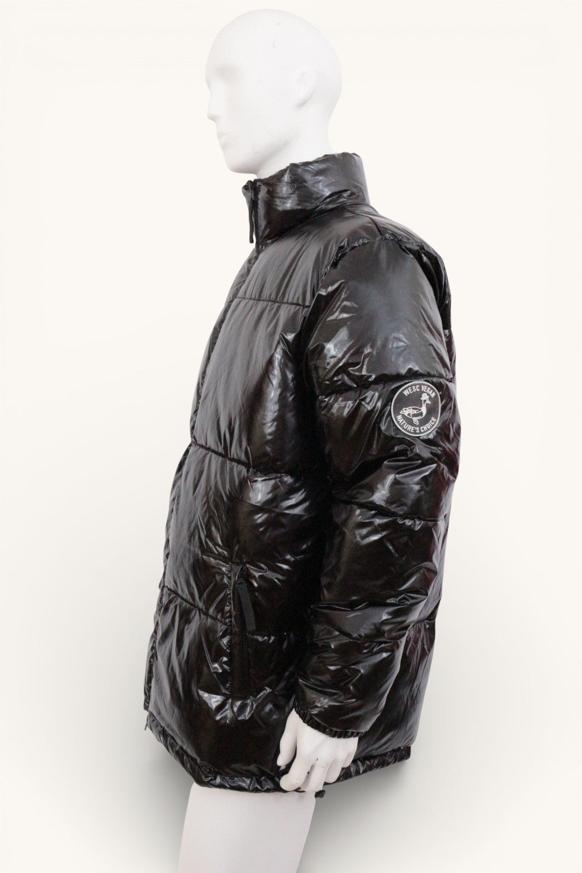 Doudoune noire brillante Frippindealz Wesc en polyester avec écusson sur la manche, vue de profil sur mannequin