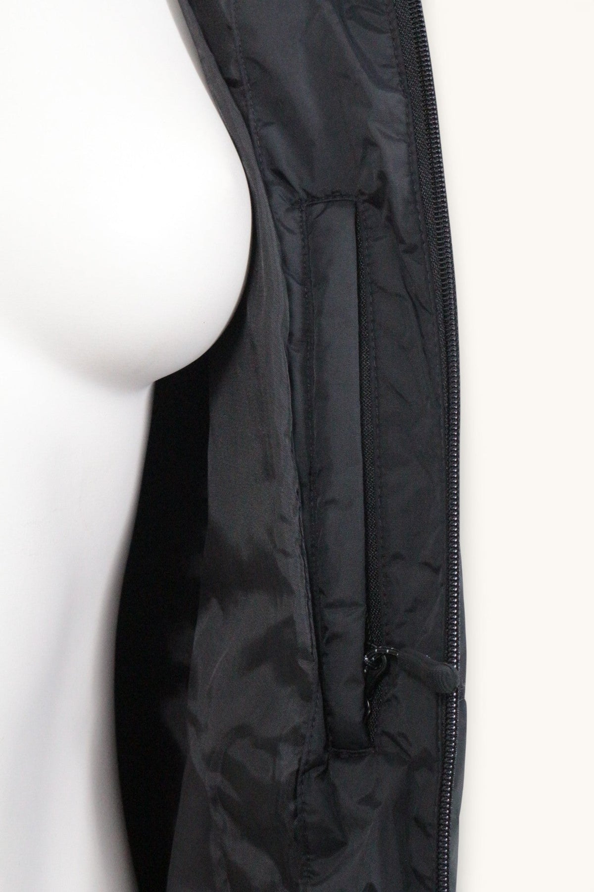 Détail de la fermeture éclair et de la poche intérieure d'une doudoune noire Frippindealz en polyester