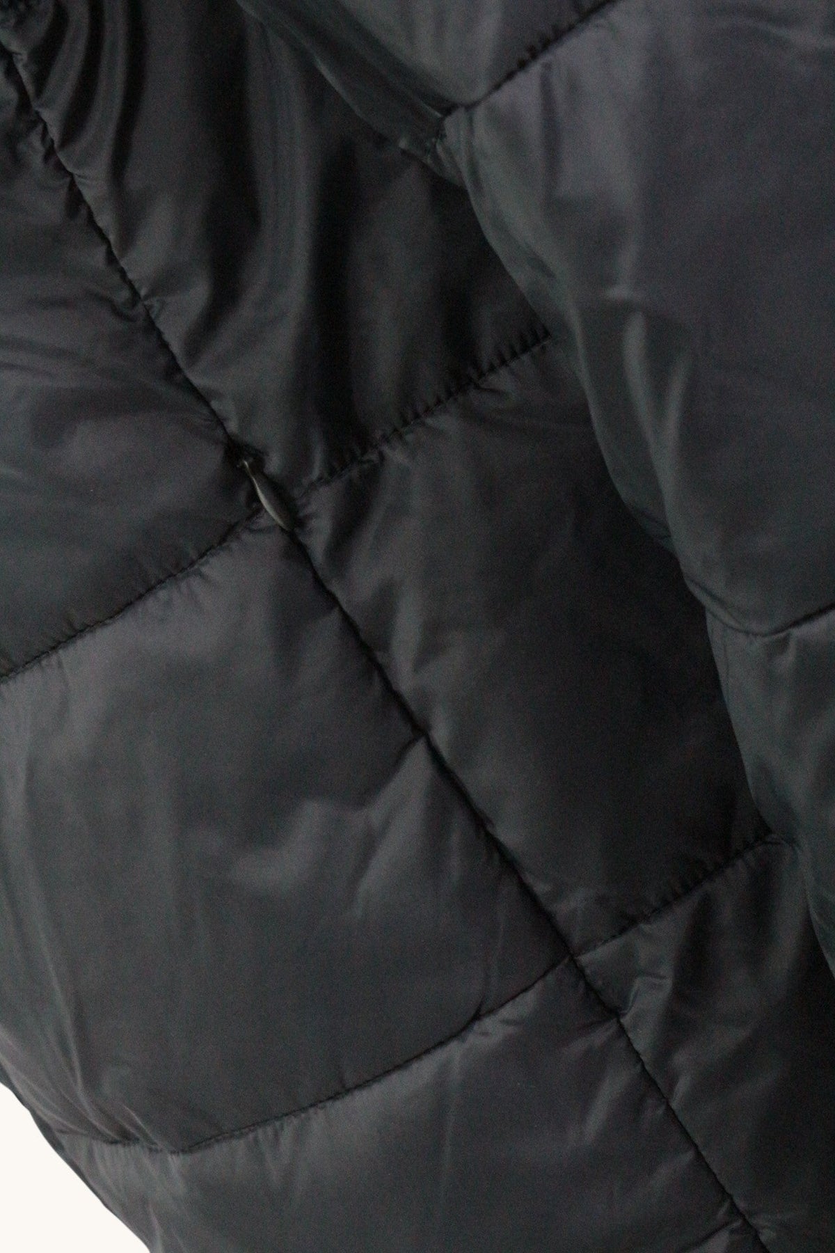 Détail de la texture matelassée noire d'une doudoune Wrangler Frippindealz avec fermeture éclair