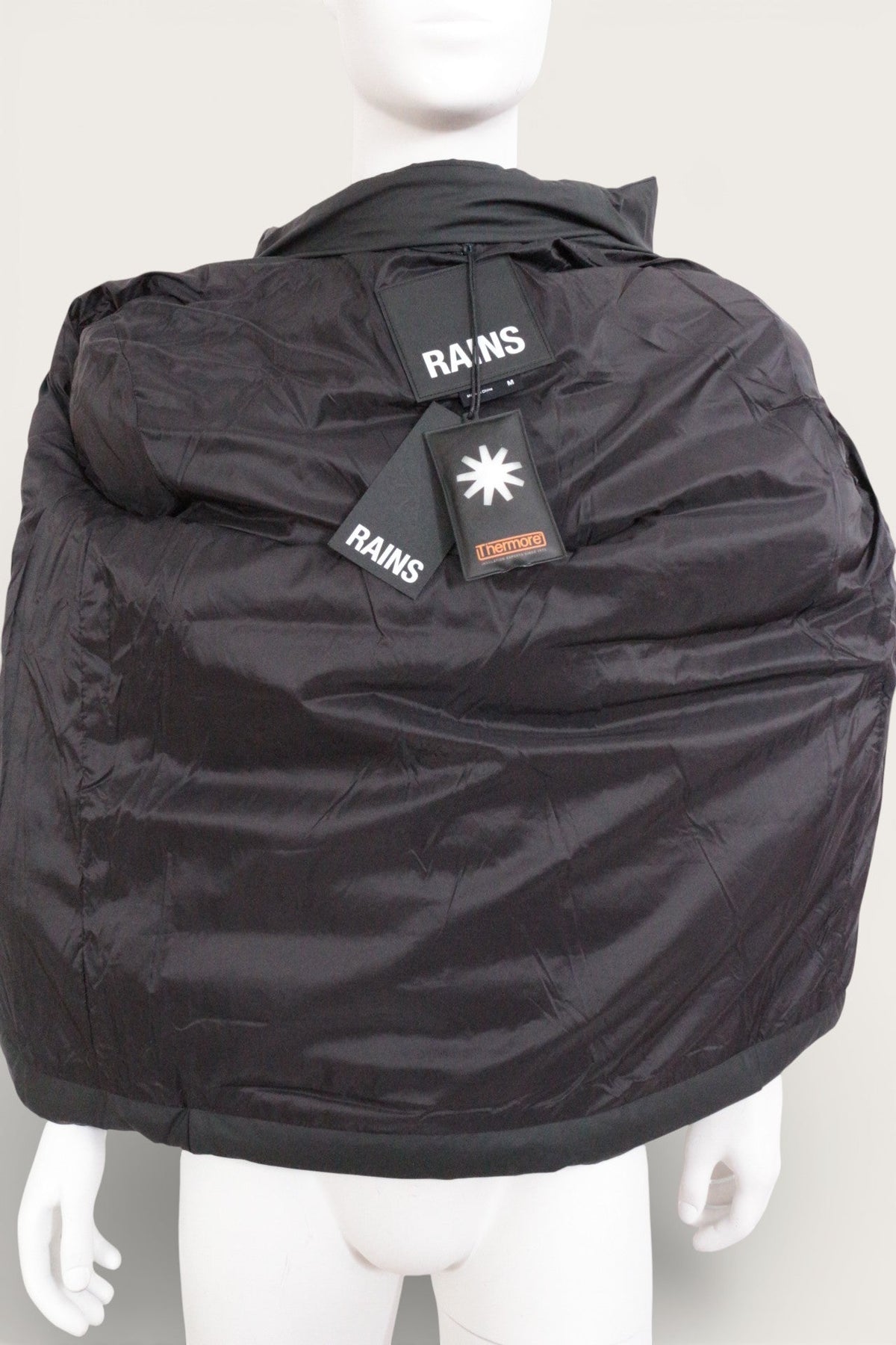 Doudoune noire Rains neuve avec étiquettes, imperméable et isolante, présentée sur un mannequin, Frippindealz
