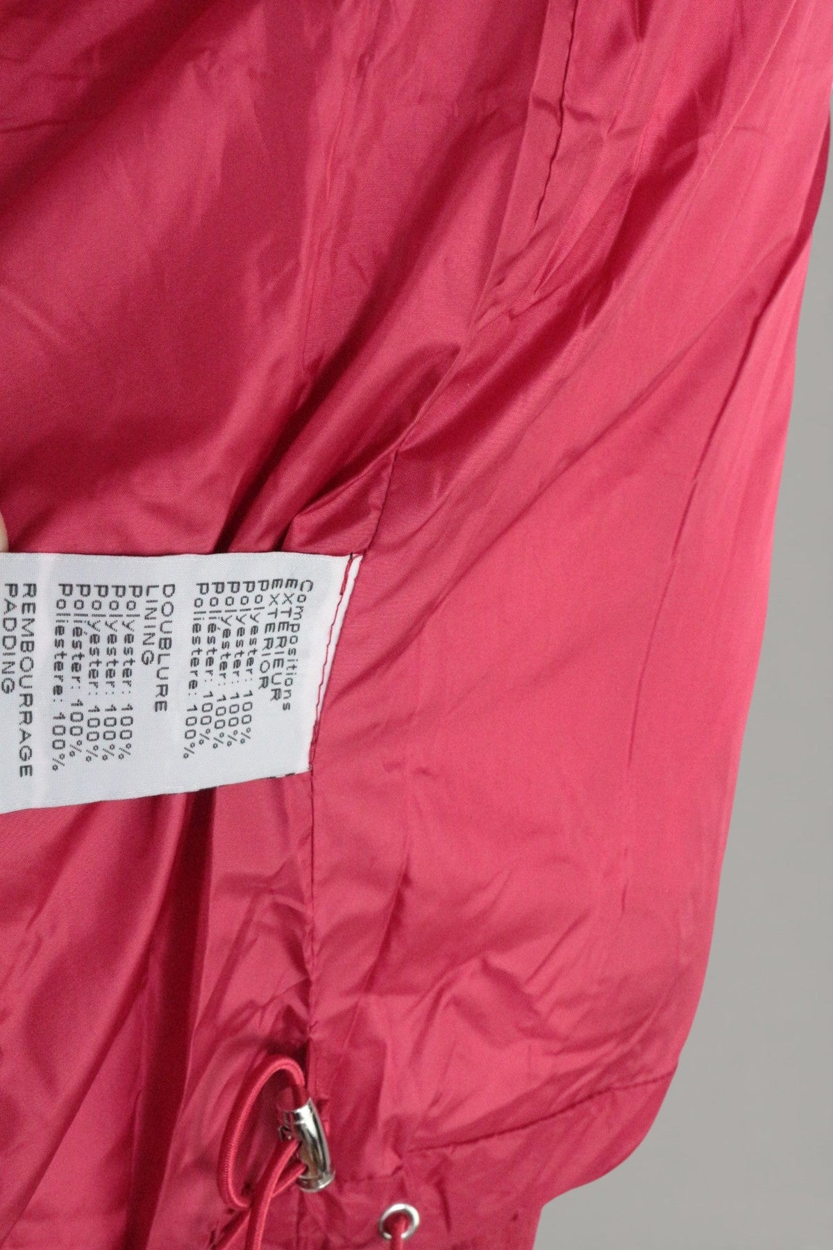 Étiquette de composition en polyester à l'intérieur d'une doudoune rouge Frippindealz