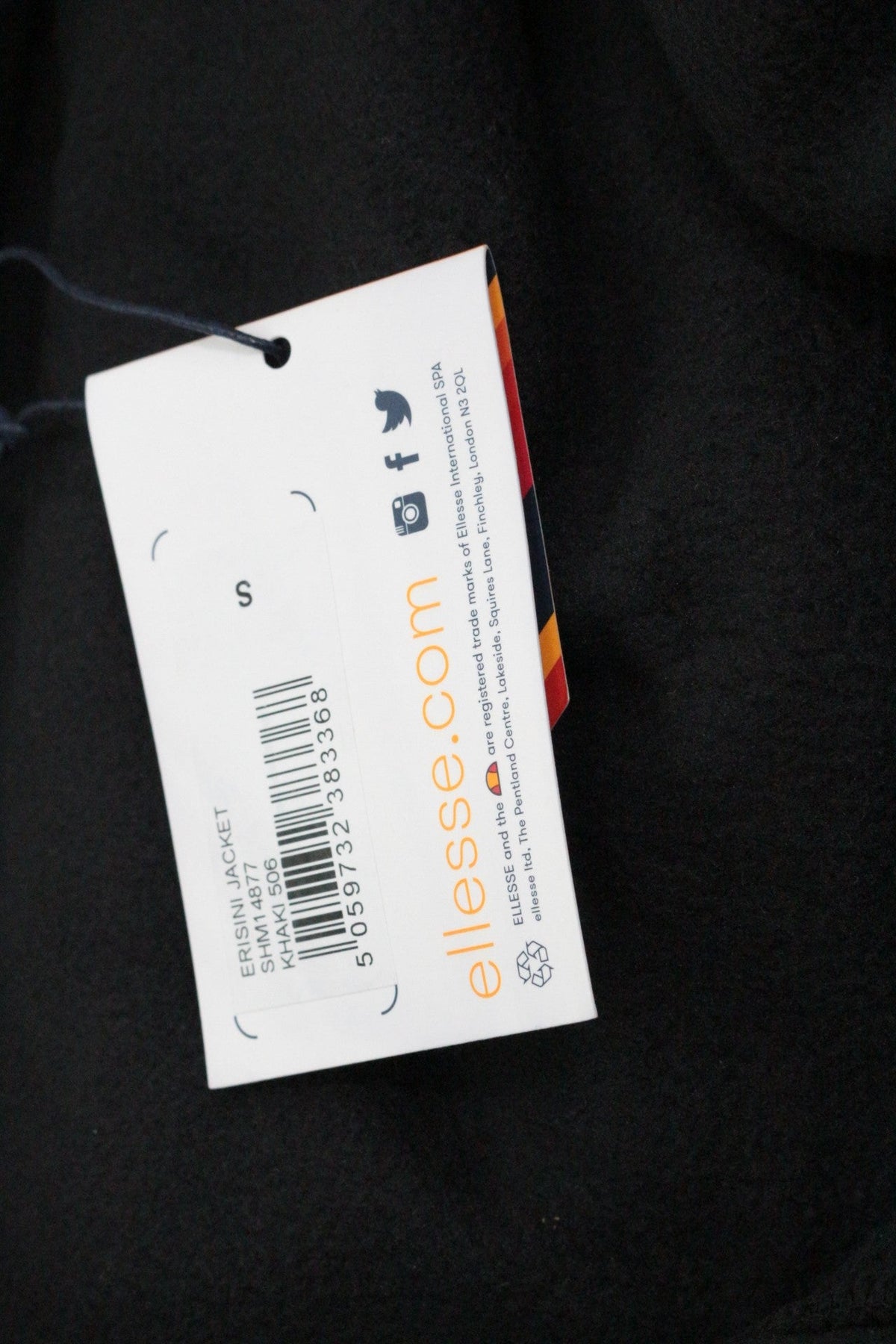 Étiquette de prix et informations produit sur un blouson Ellesse noir chez Frippindealz