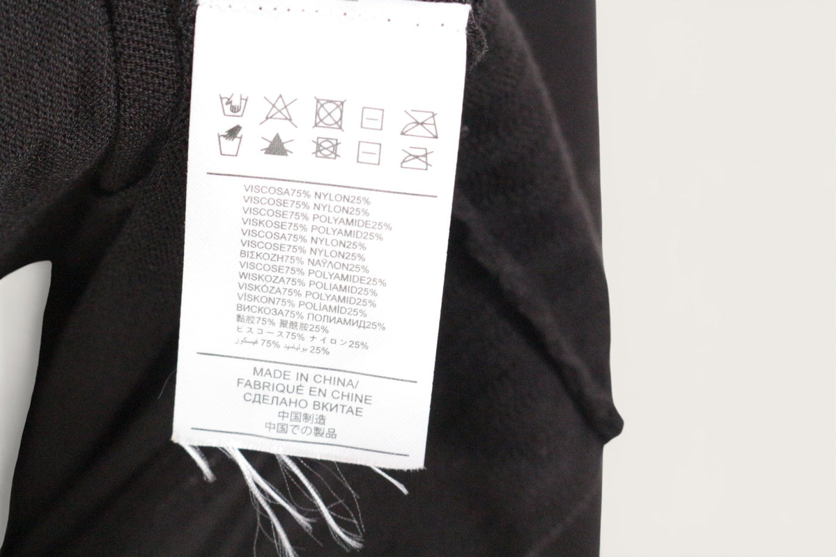 Étiquette de composition Frippindealz sur un pull noir en viscose et polyamide avec instructions de lavage