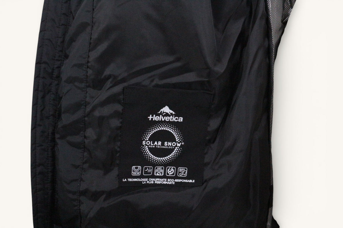 Doublure intérieure noire d'une doudoune Frippindealz Helvetica avec étiquette technologique Solar Snow