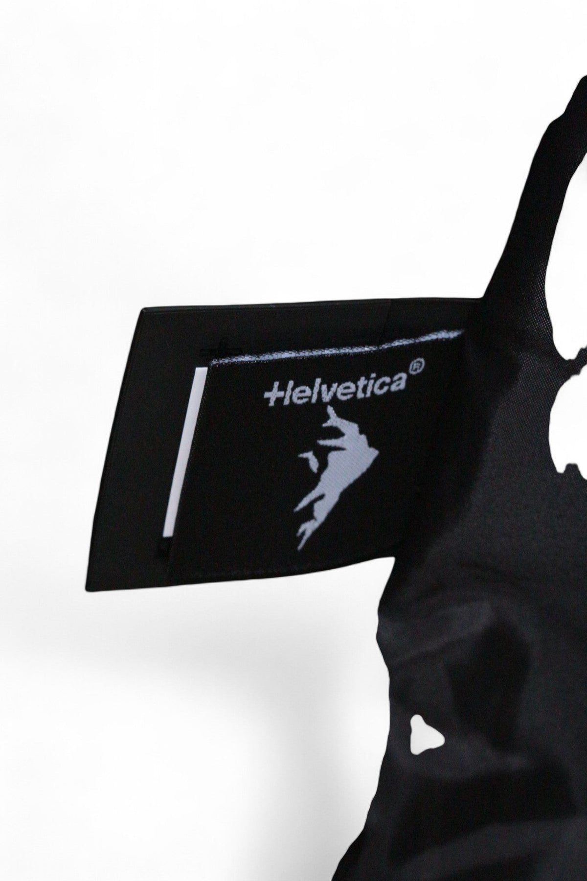 Étiquette de marque noire Helvetica sur une parka longue en polyester, vendue par Frippindealz
