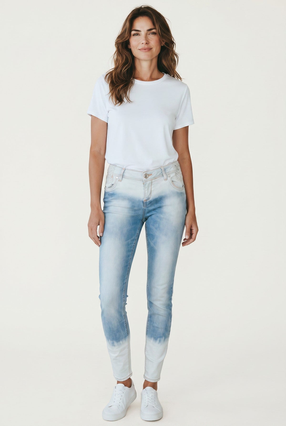 Jean slim Frippindealz bleu dégradé avec détails en dentelle porté par une femme avec un t-shirt blanc