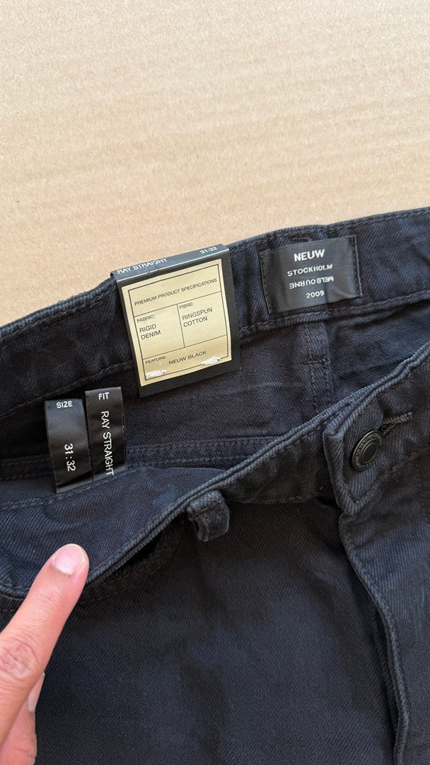 Détail de la ceinture d'un jeans noir Frippindealz Neuw coupe droite en coton rigide avec étiquettes d'origine
