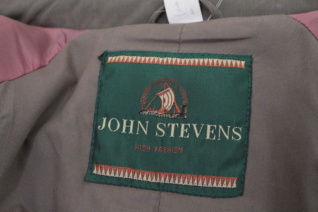 Étiquette de marque John Stevens à l'intérieur d'un trench kaki Frippindealz avec doublure contrastée