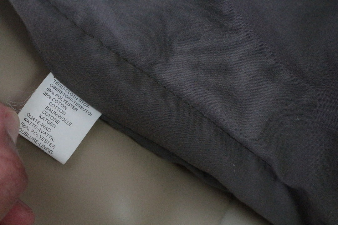 Étiquette de composition textile du trench Frippindealz John Stevens indiquant 65% polyester et 35% coton
